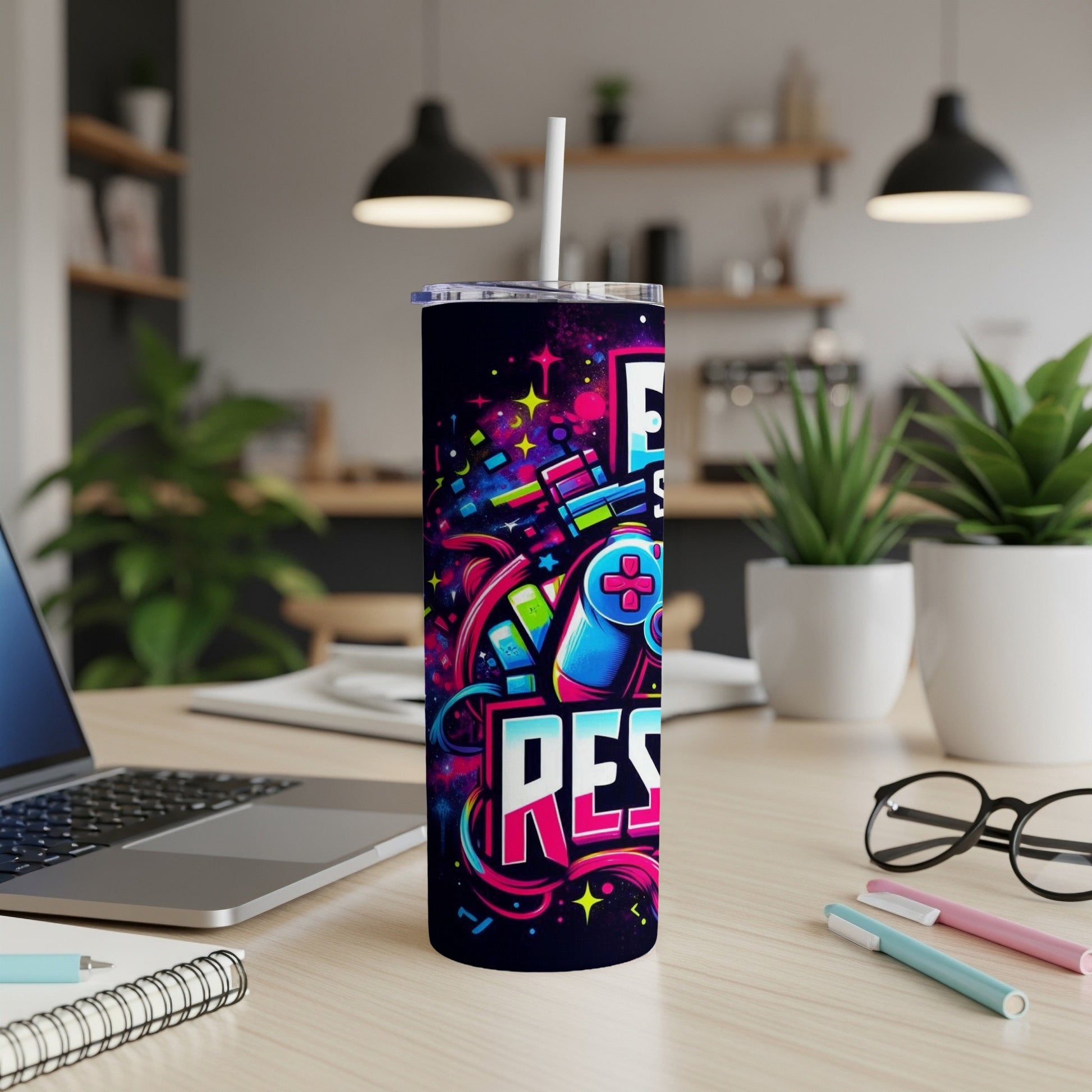 Tall tumbler with vibrant "EAT SLEEP REPEAT" gamer design and a game controller.
