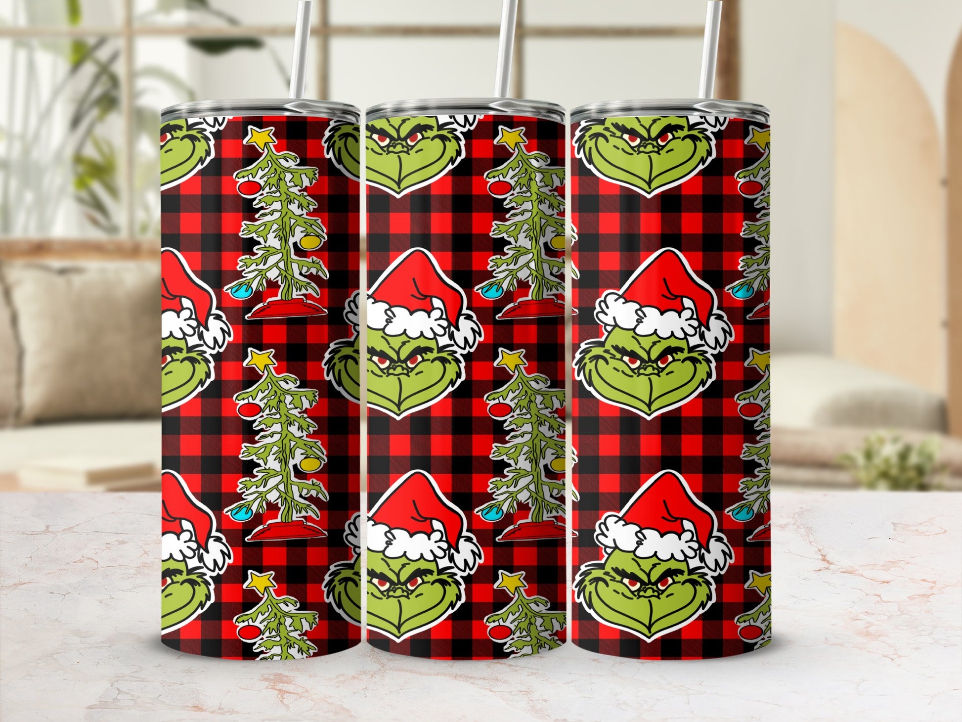 Three Grinch tumblers with Santa hats and Christmas trees on red plaid background.