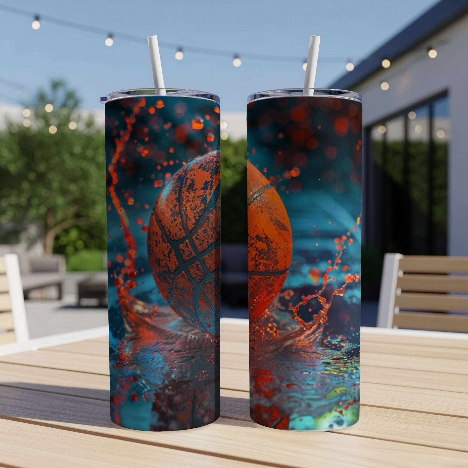 Two tall tumblers with basketball splashing liquid on outdoor table.