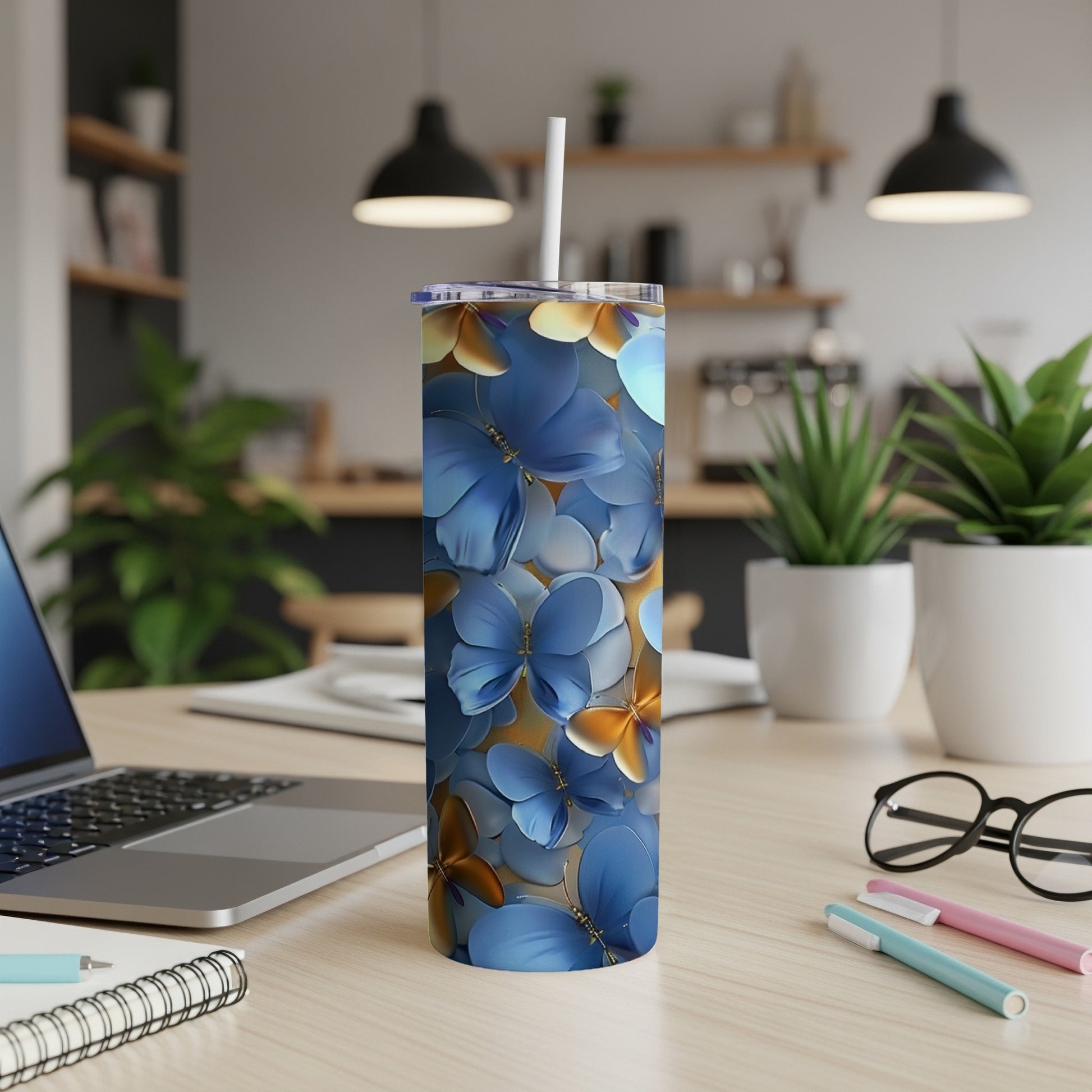 Blue floral pattern tumbler with straw on a desk.