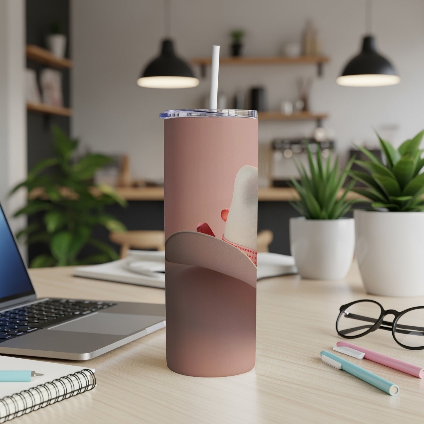 Dusty rose tumbler with a white cowboy hat graphic and red band.