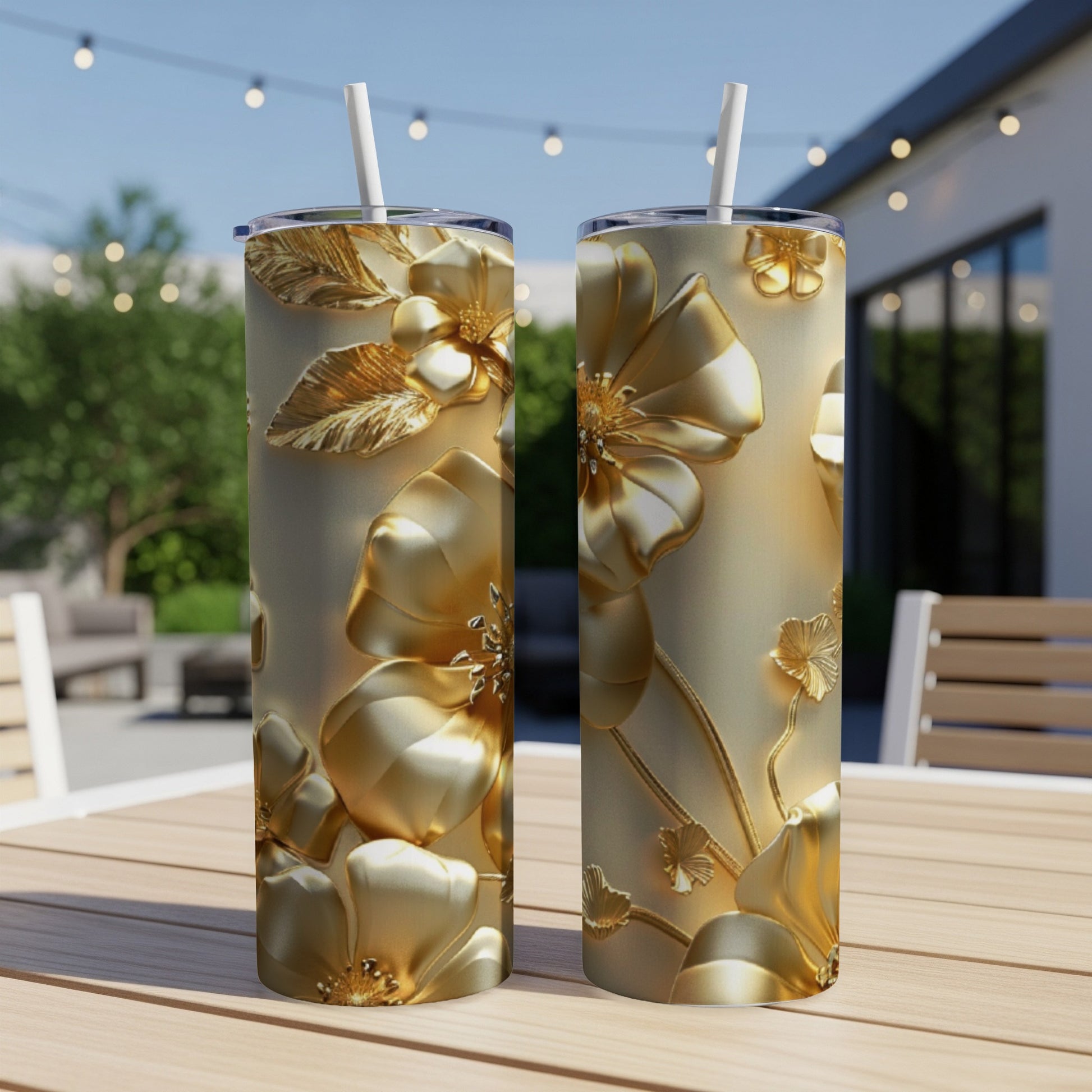 Two gold tumblers with embossed floral designs on a wooden table.
