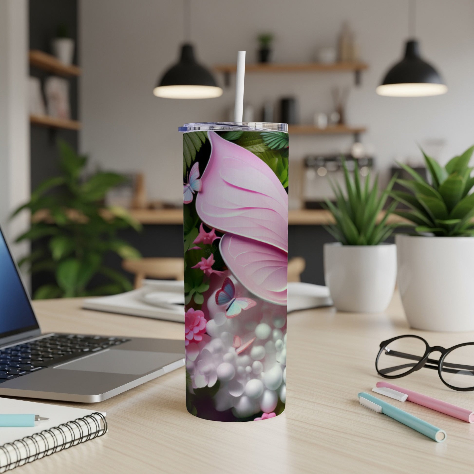 Pink flamingo floral pattern tumbler with straw on a desk.