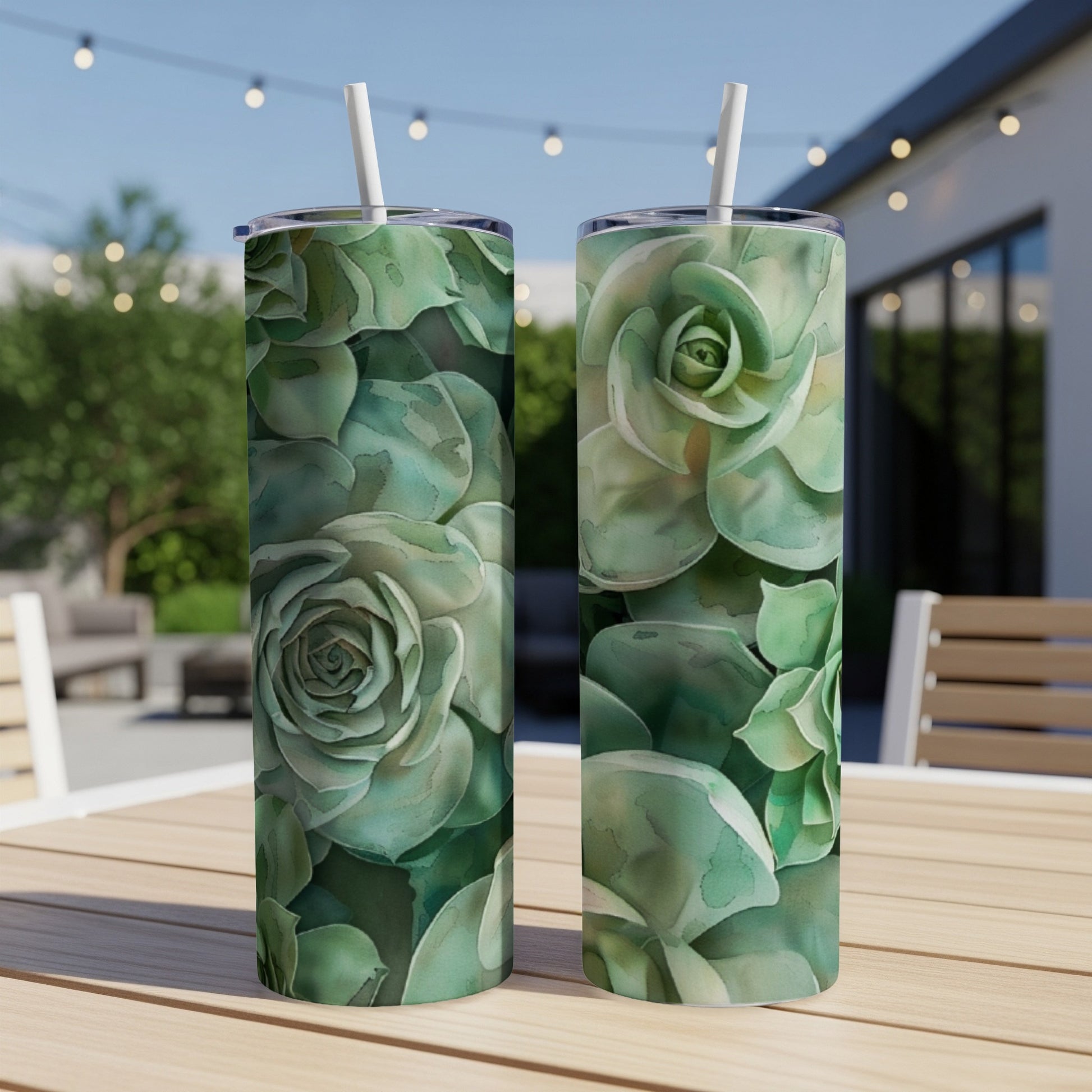 Two tumblers with a watercolor succulent floral pattern on a wooden table.