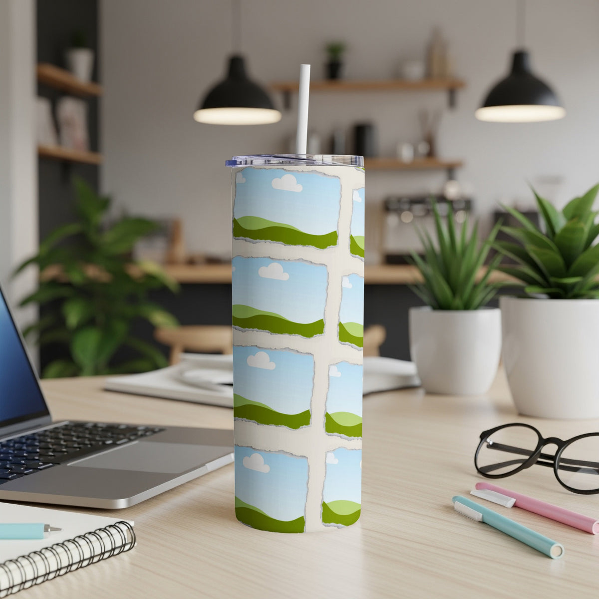 Tumbler with torn polaroid style landscape photos and a straw.