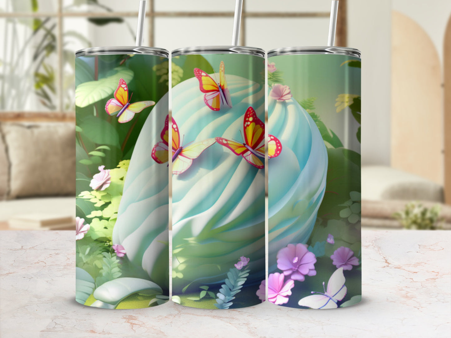 Three tumblers with pastel swirl design and butterflies, against a blurred background.