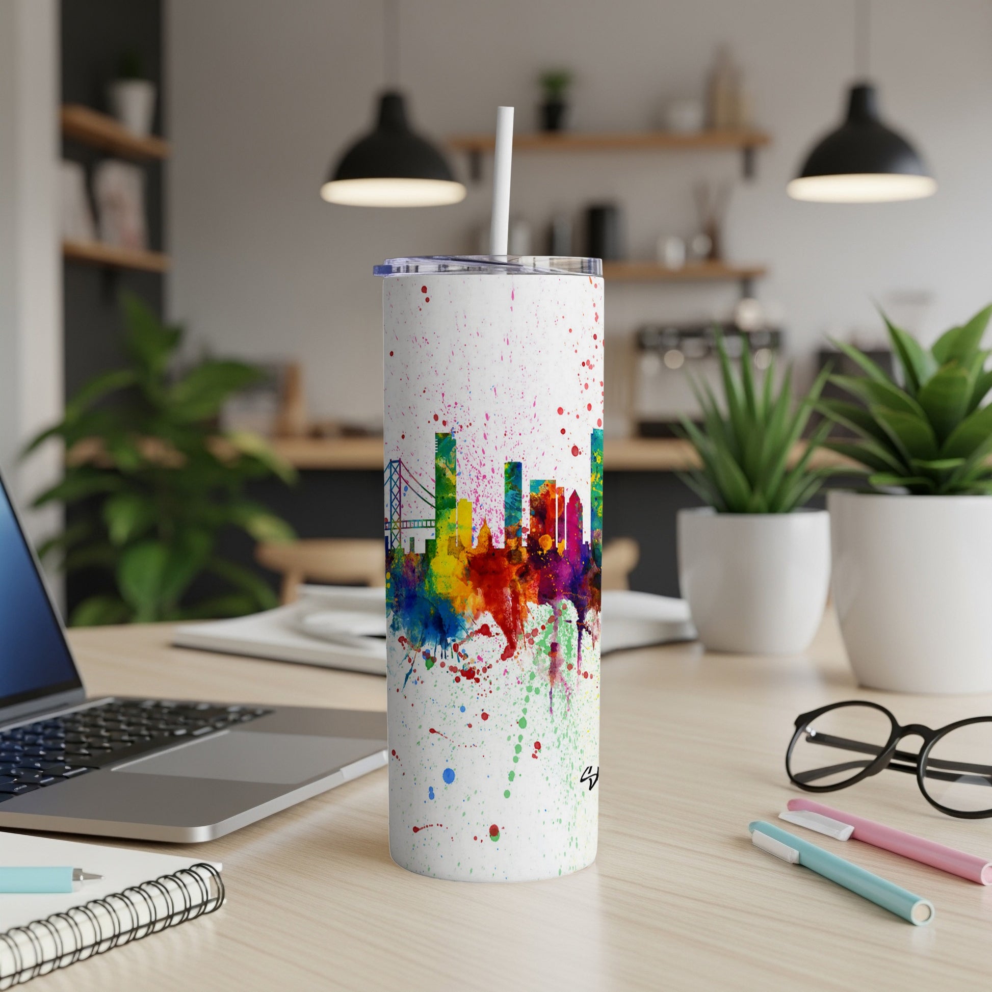 White tumbler with multicolor paint splatter and city skyline design.