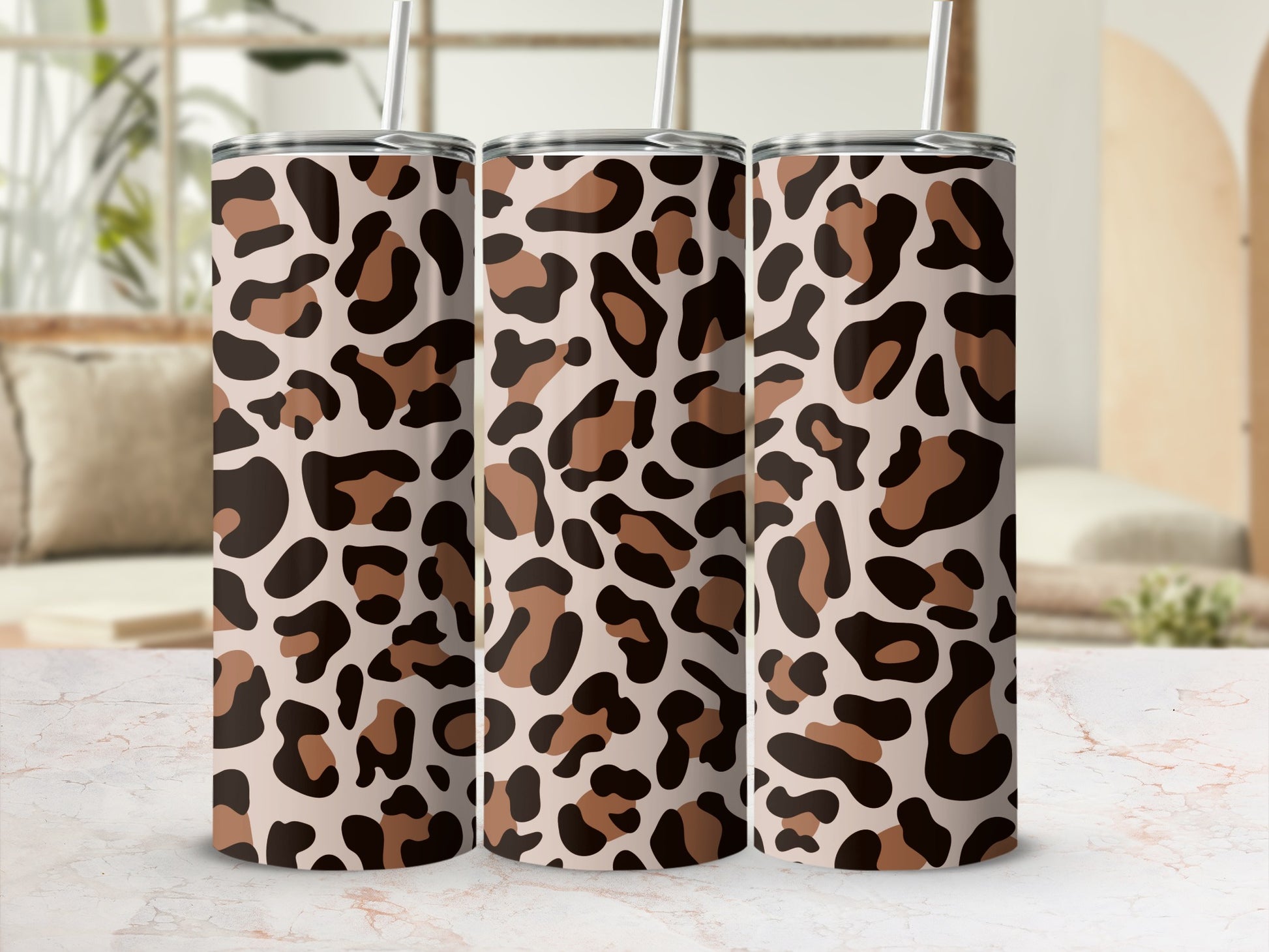 Three tumblers with a leopard print pattern and straws.