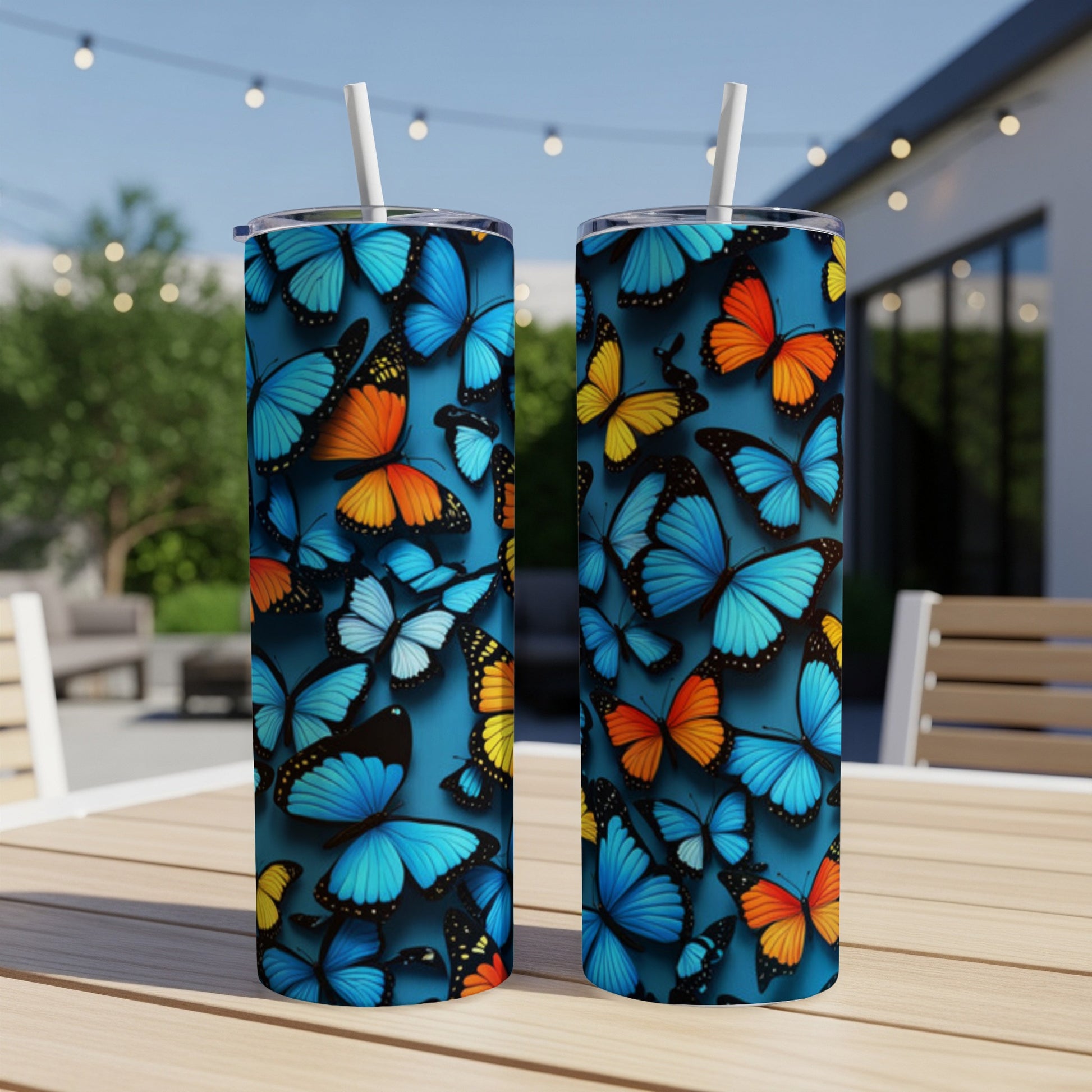 Two blue and orange butterfly pattern tumblers on a wooden table.