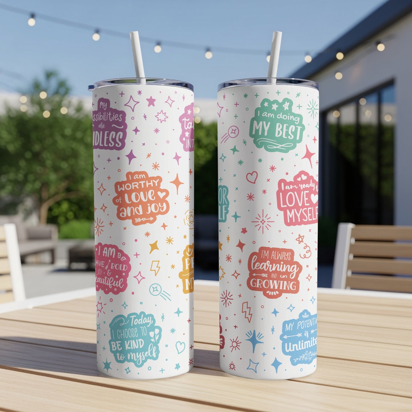 Two insulated tumblers with inspirational quotes and colorful graphic designs.