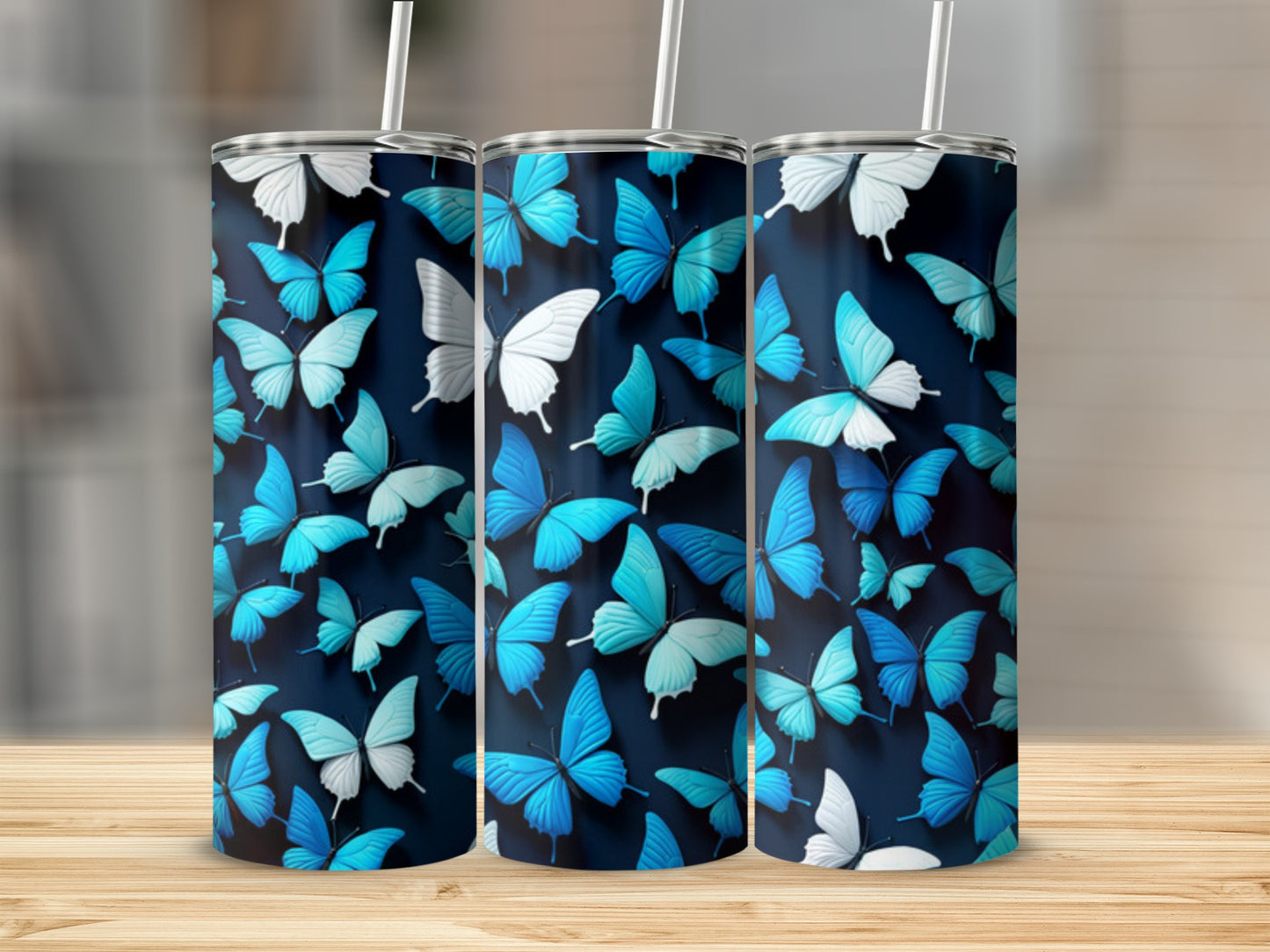 Three tumblers with blue butterfly pattern on dark background.