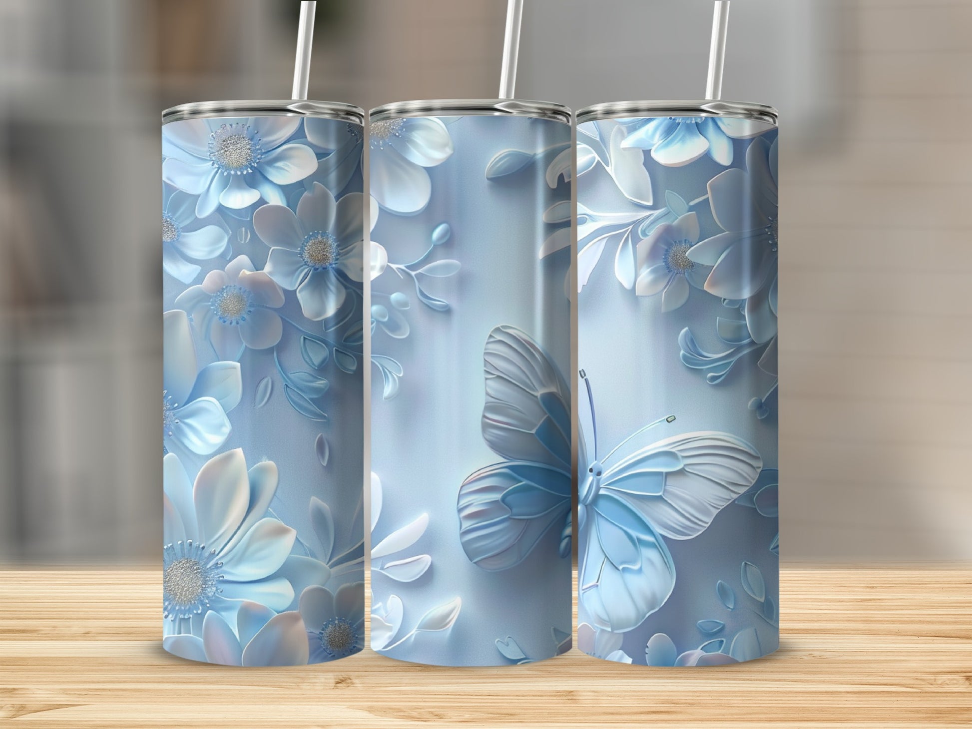 Three pale blue tumblers with floral and butterfly designs.