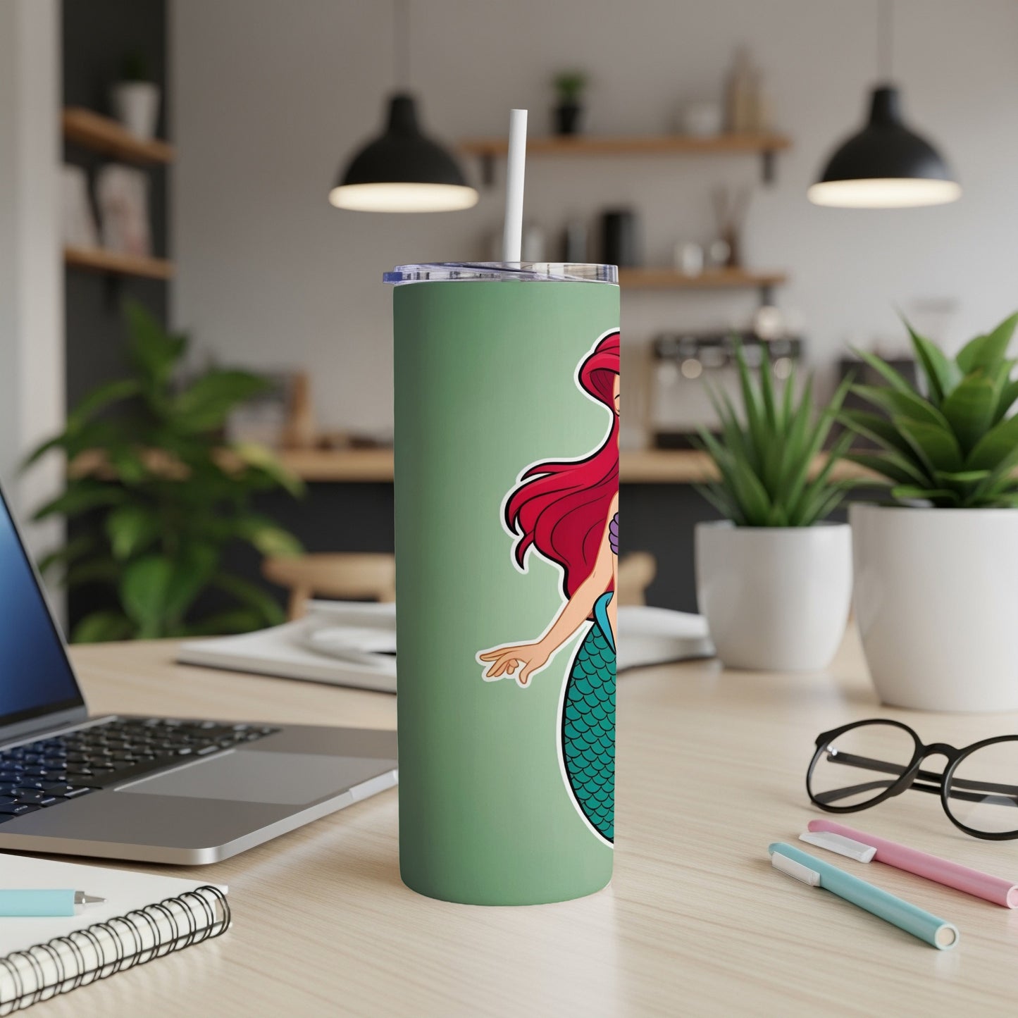 Ariel from The Little Mermaid on a sage green tumbler with a straw.