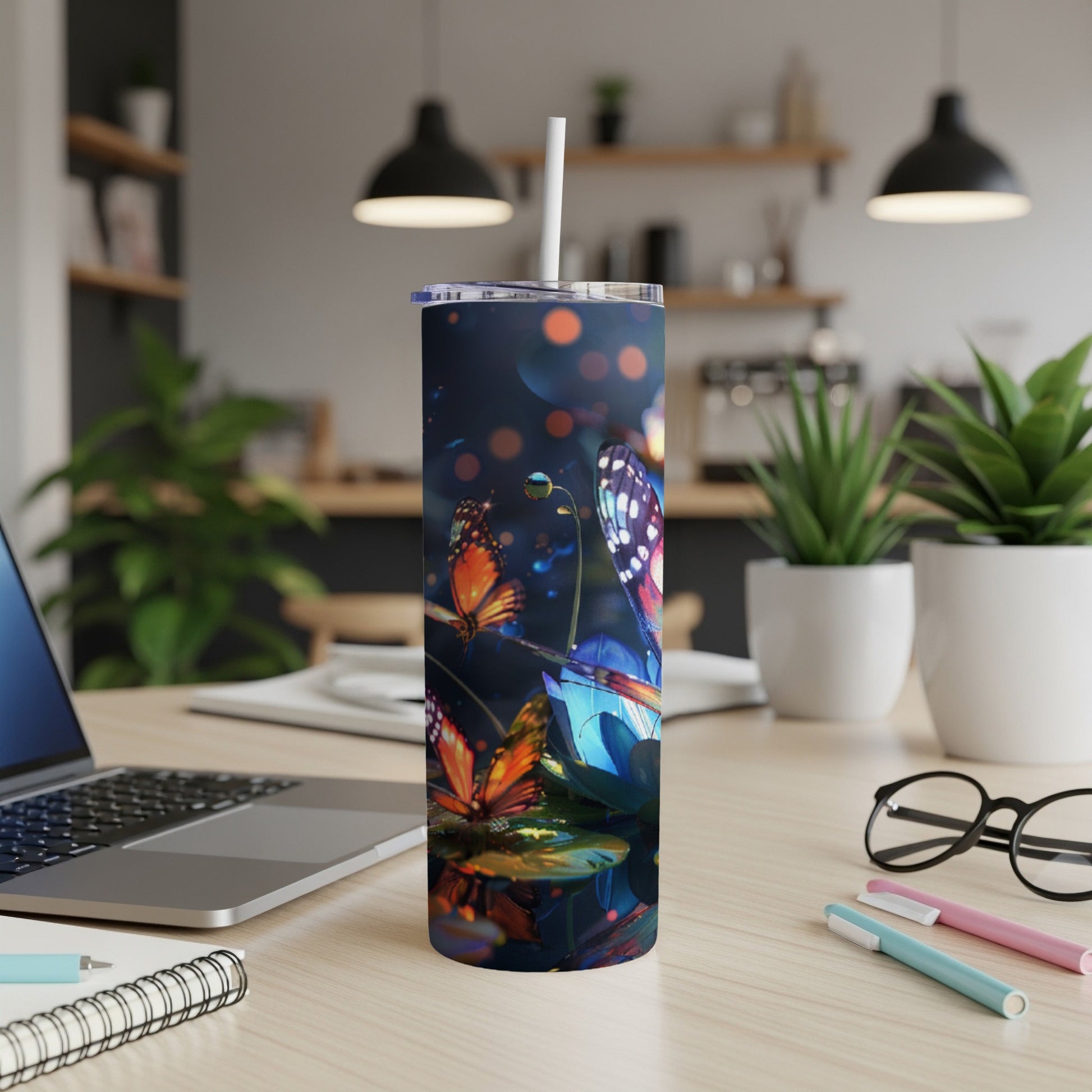 Blue tumbler with iridescent butterflies and bokeh lights, on a desk.