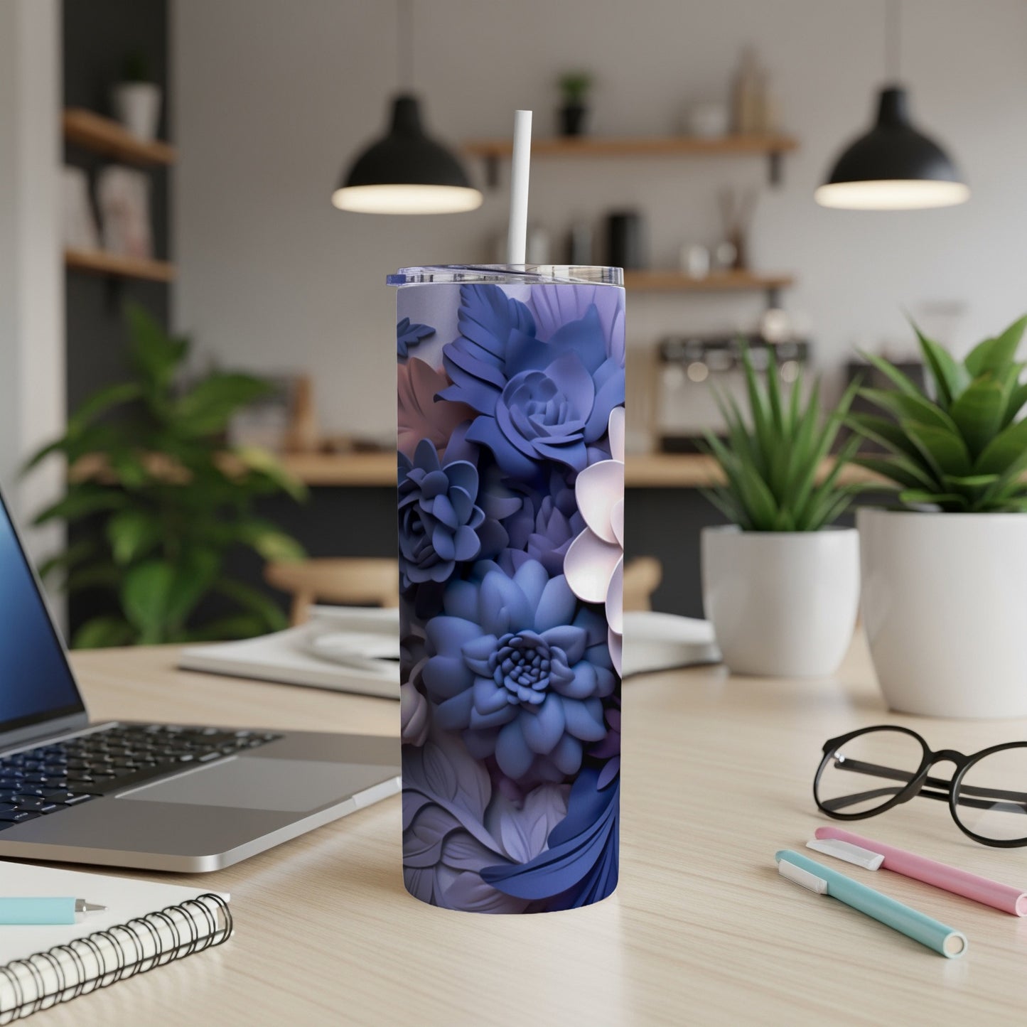 Blue and purple floral tumbler with straw on desk.