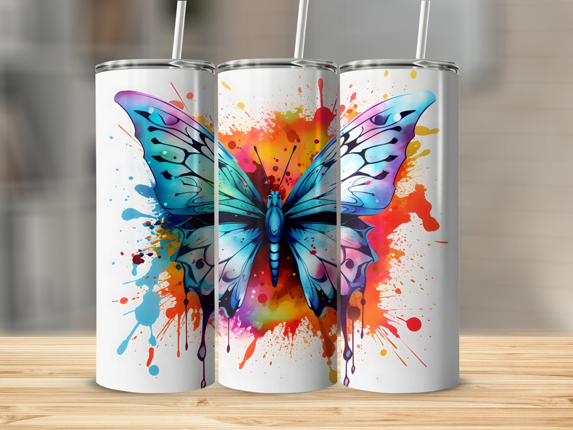 Three tumblers featuring a blue butterfly with colorful paint splatters.