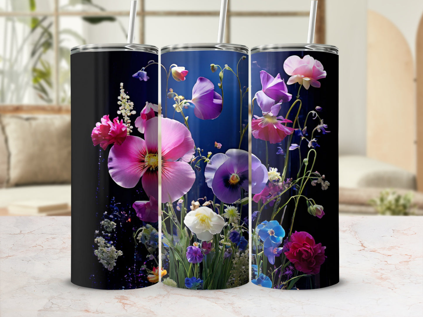 Three tumblers with vibrant floral designs on a marble surface.
