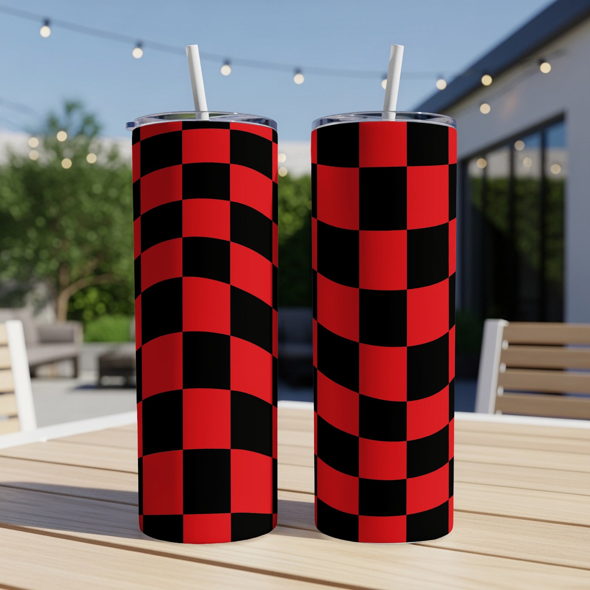 Two tumblers with a red and black checkered pattern sit on a table.