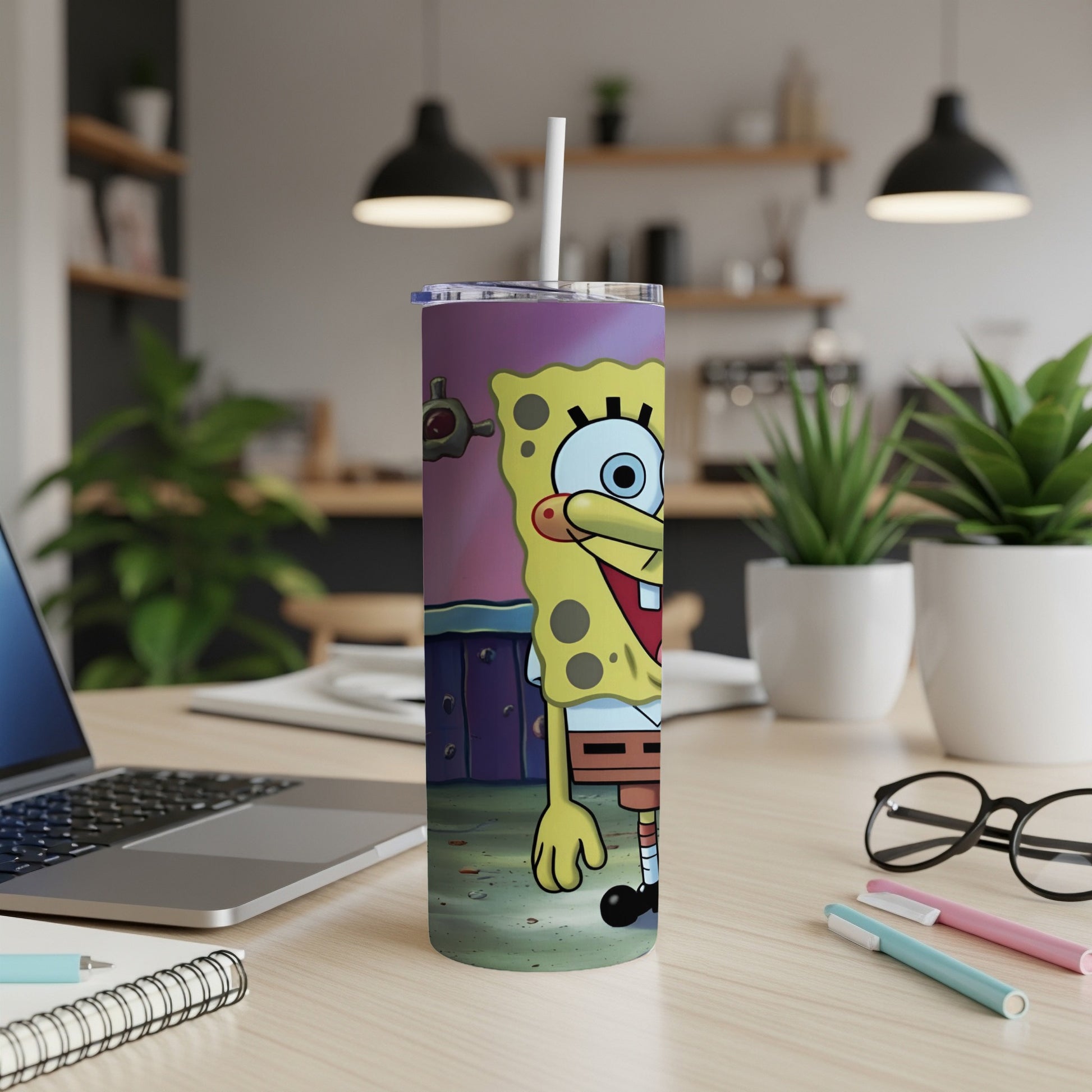 SpongeBob SquarePants tumbler with a straw in a home office setting.