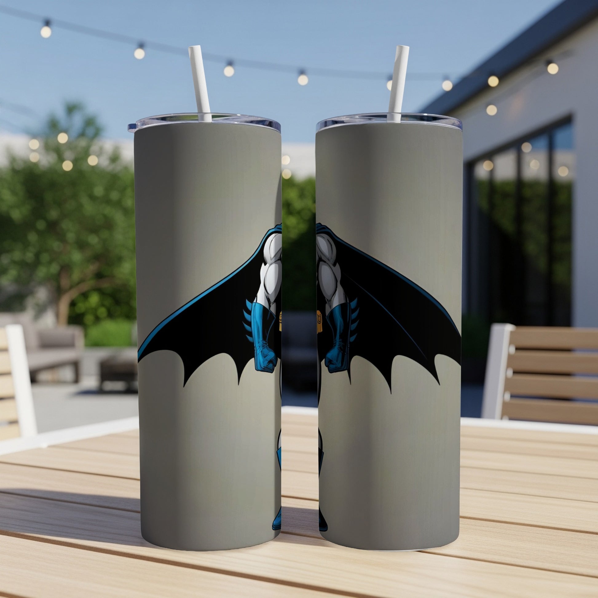 Two stainless steel tumblers with Batman graphic on a wooden table.