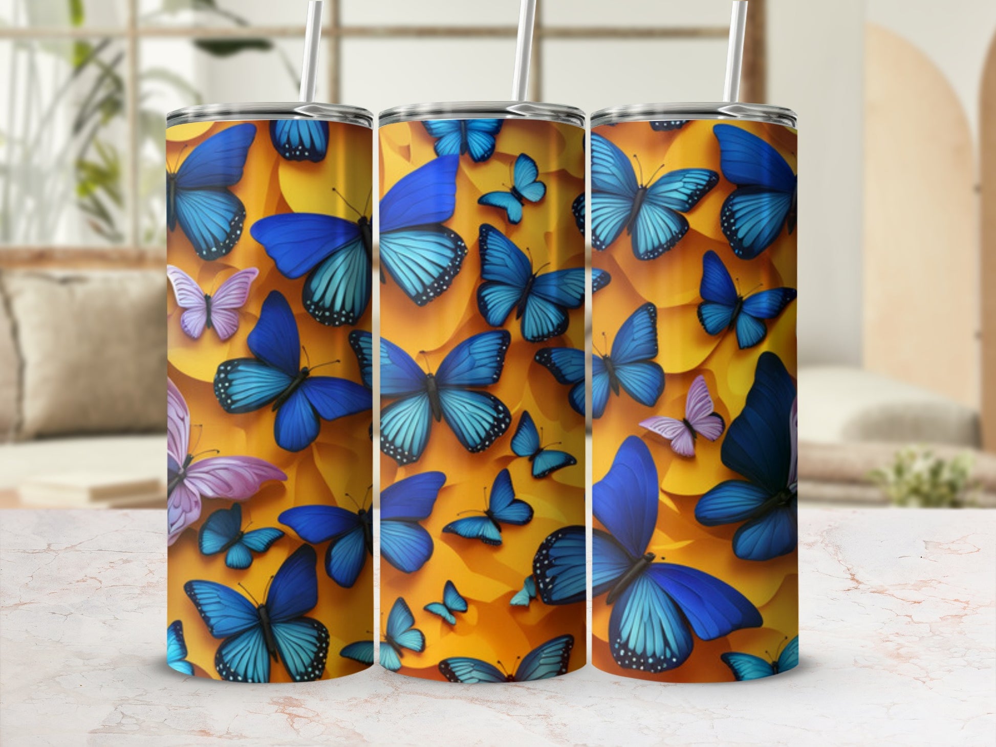 Three tumblers with a vibrant blue butterfly pattern, a straw in each.