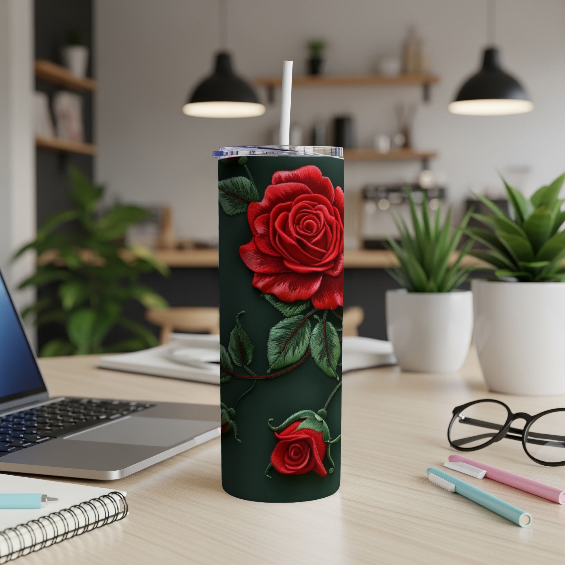 Red rose tumbler with a straw on a desk.