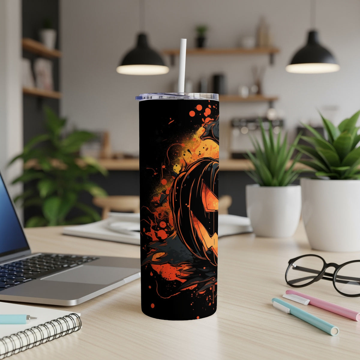 Black tumbler with a graphic of a Halloween pumpkin, bats, and orange splatters.