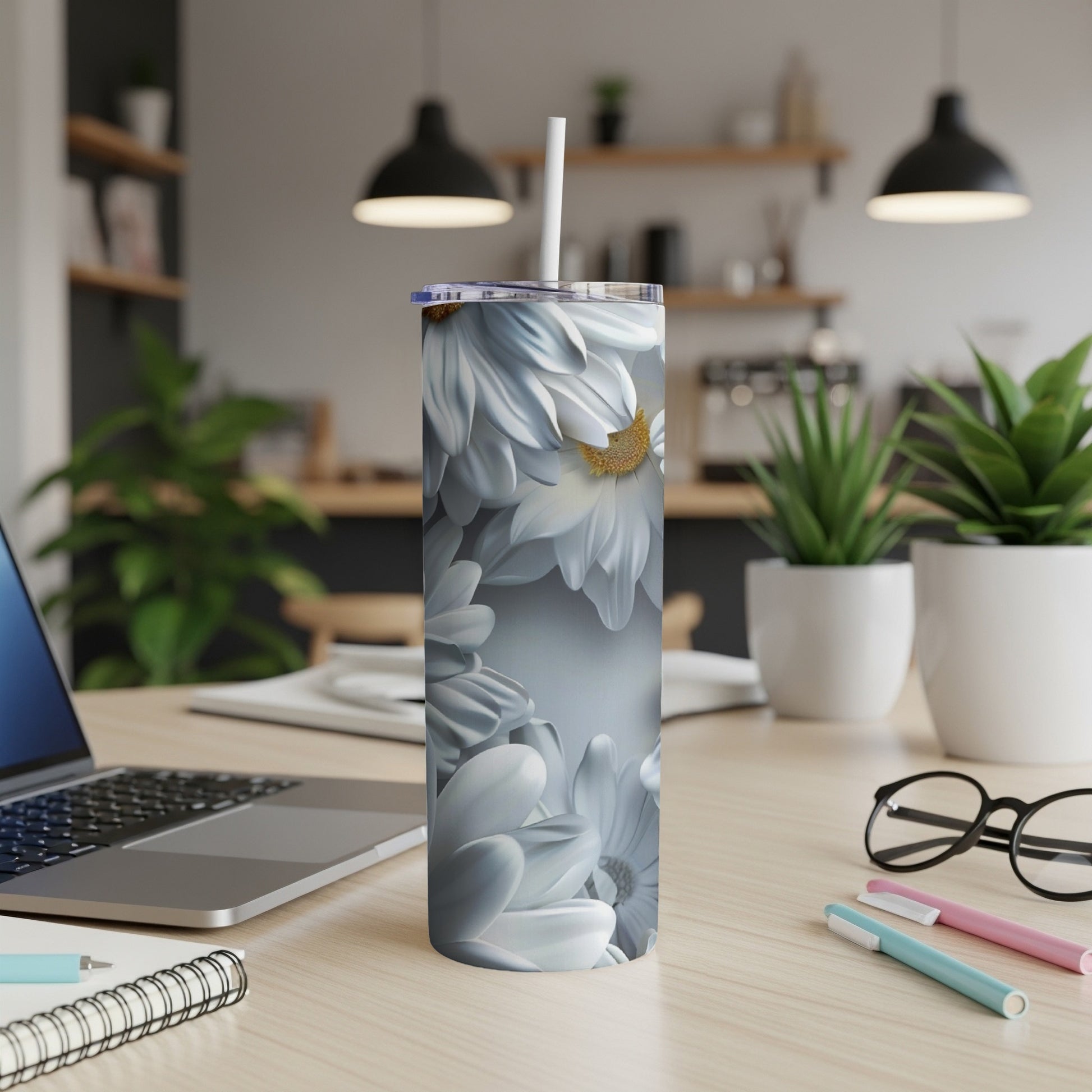 White daisy flowers wrap around a white tumbler with a straw.