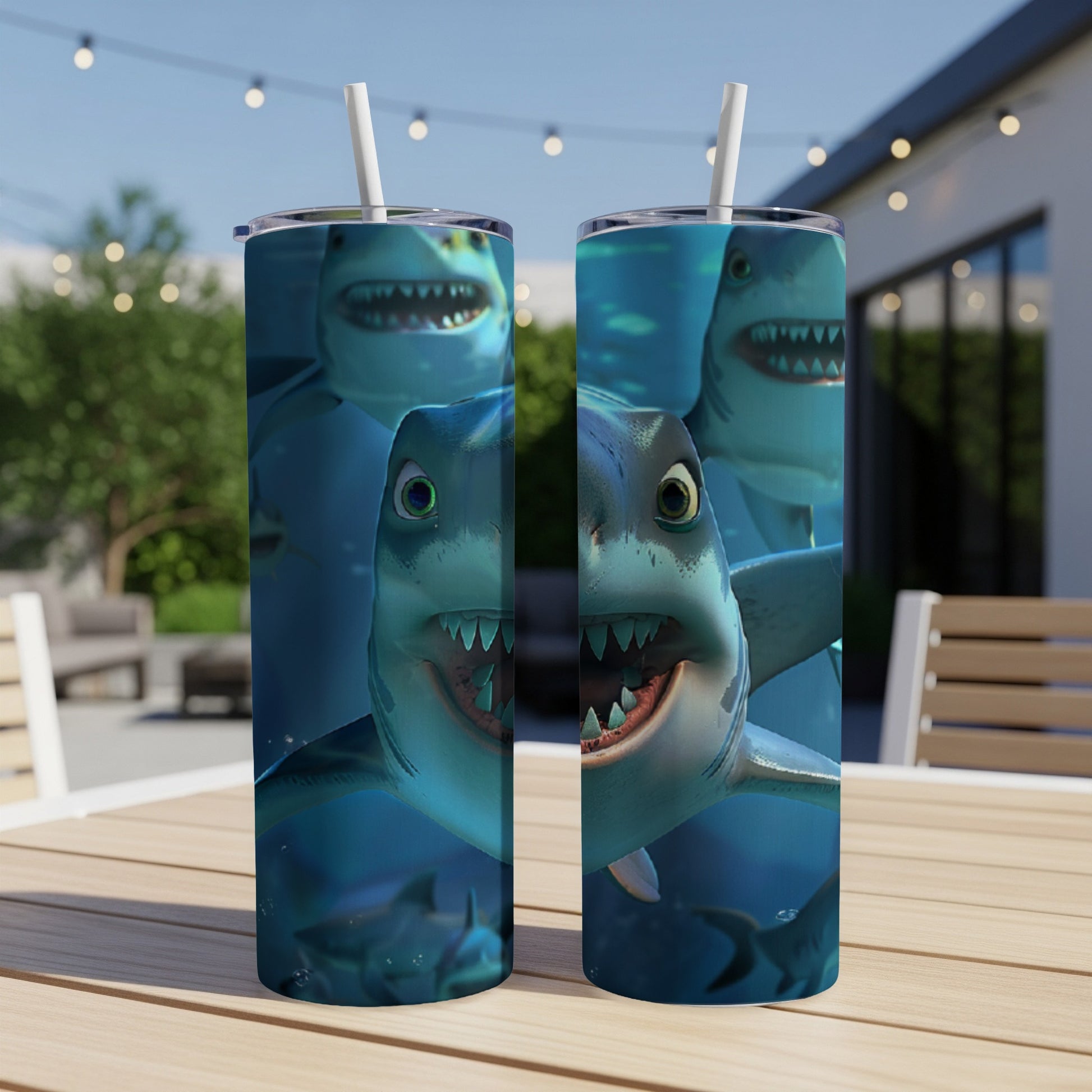 Two tumblers with cartoon shark faces on a table.