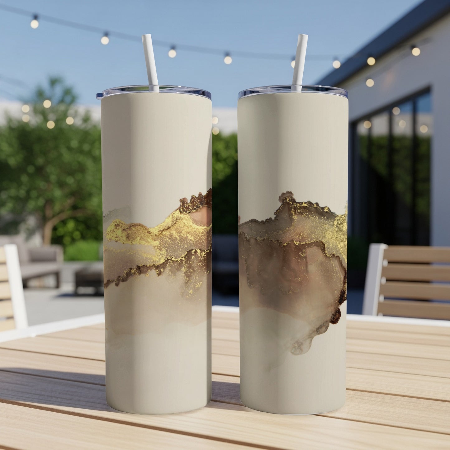 Two cream tumblers with abstract gold and brown marbling designs.
