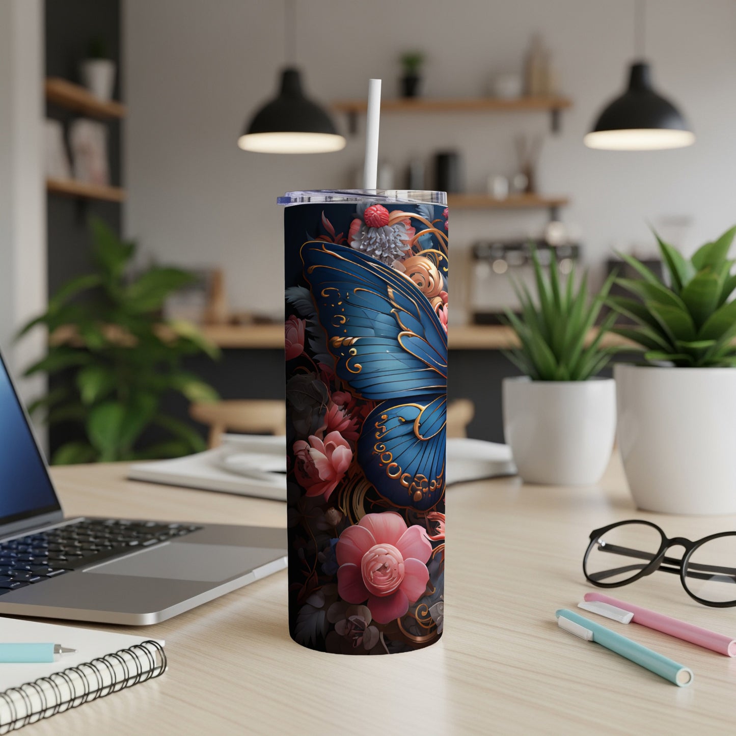 Tumbler with blue butterfly and floral design, a straw inserted.