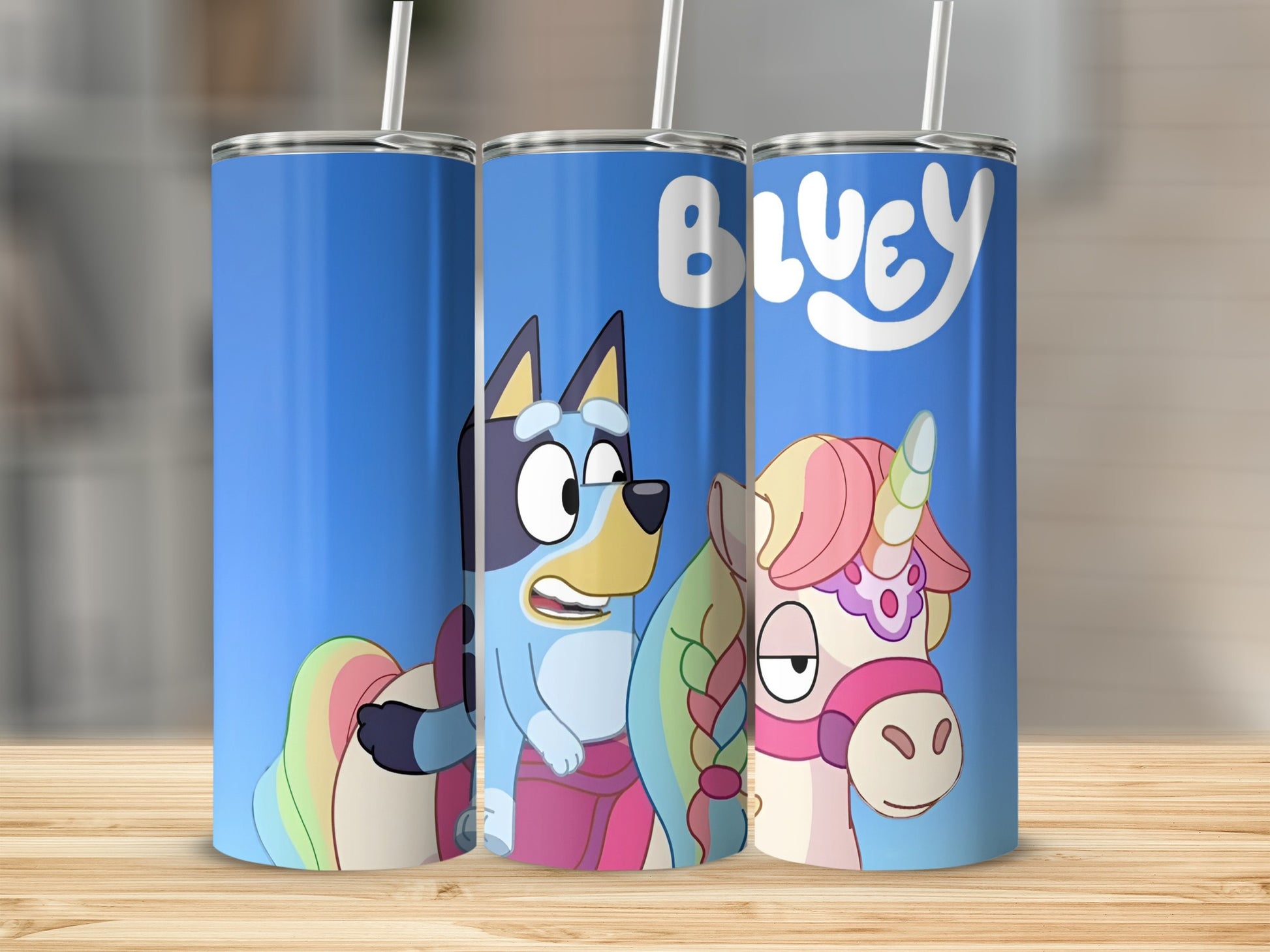 Bluey and Bingo characters on a blue tumbler with a rainbow tail.
