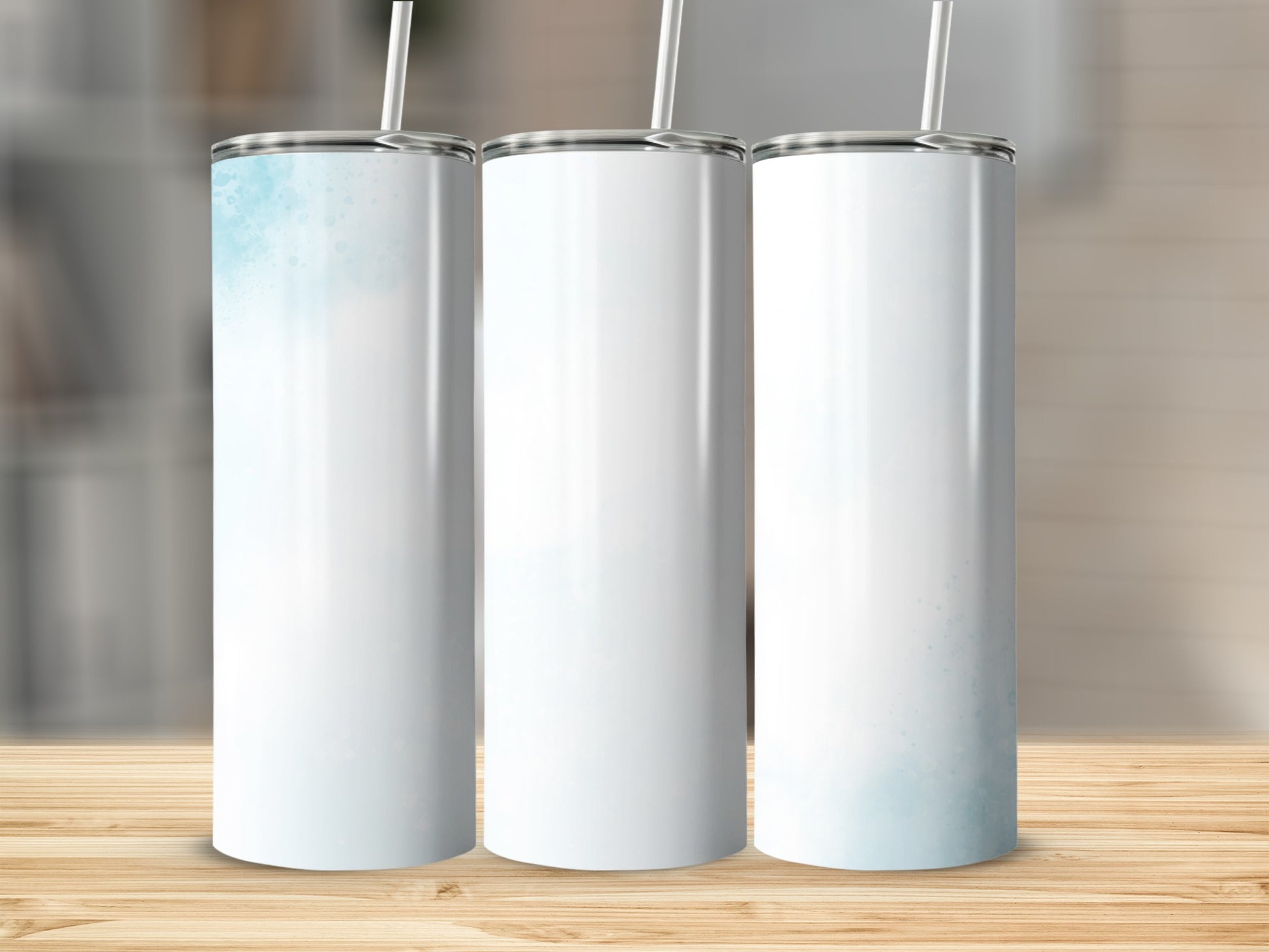 Three white tumblers with light blue watercolor accents and straws.