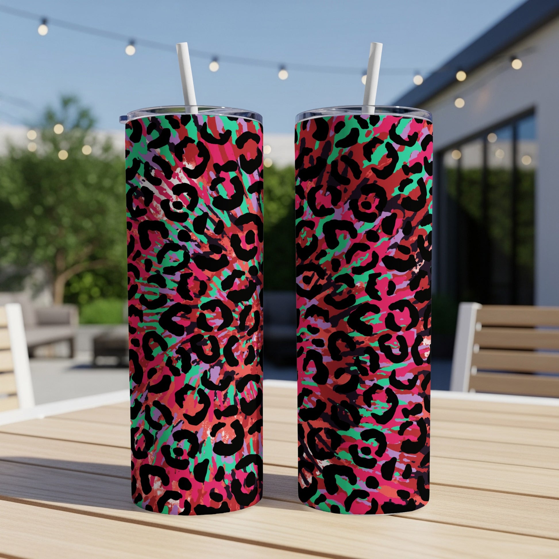 Two tumblers with a vibrant pink, black, and teal abstract leopard print pattern.