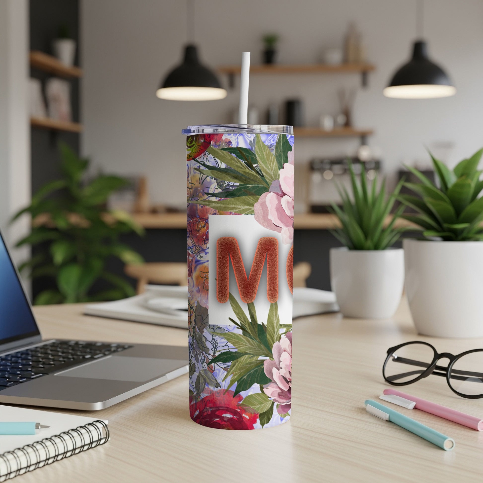 Floral tumbler with "Mom" text and a straw, on a desk.