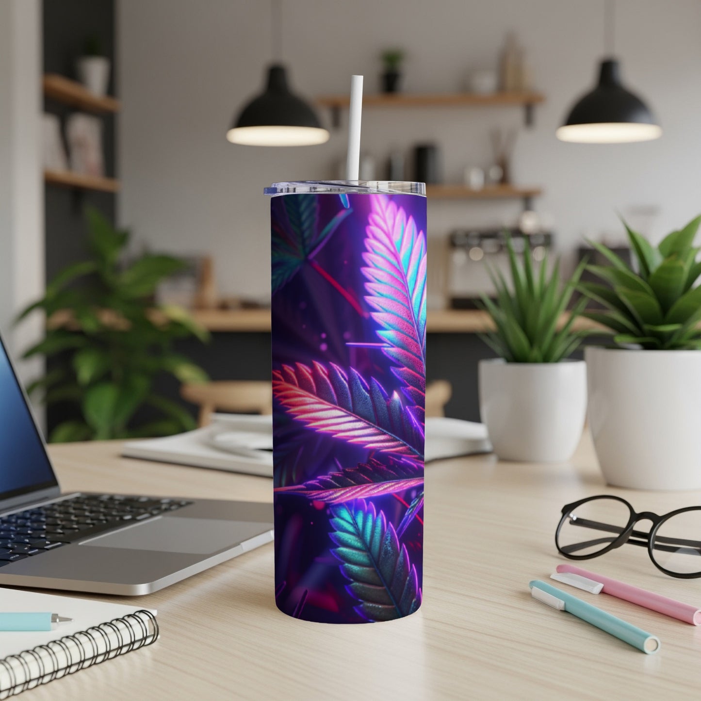 Tumbler with glowing cannabis leaf pattern on a desk.