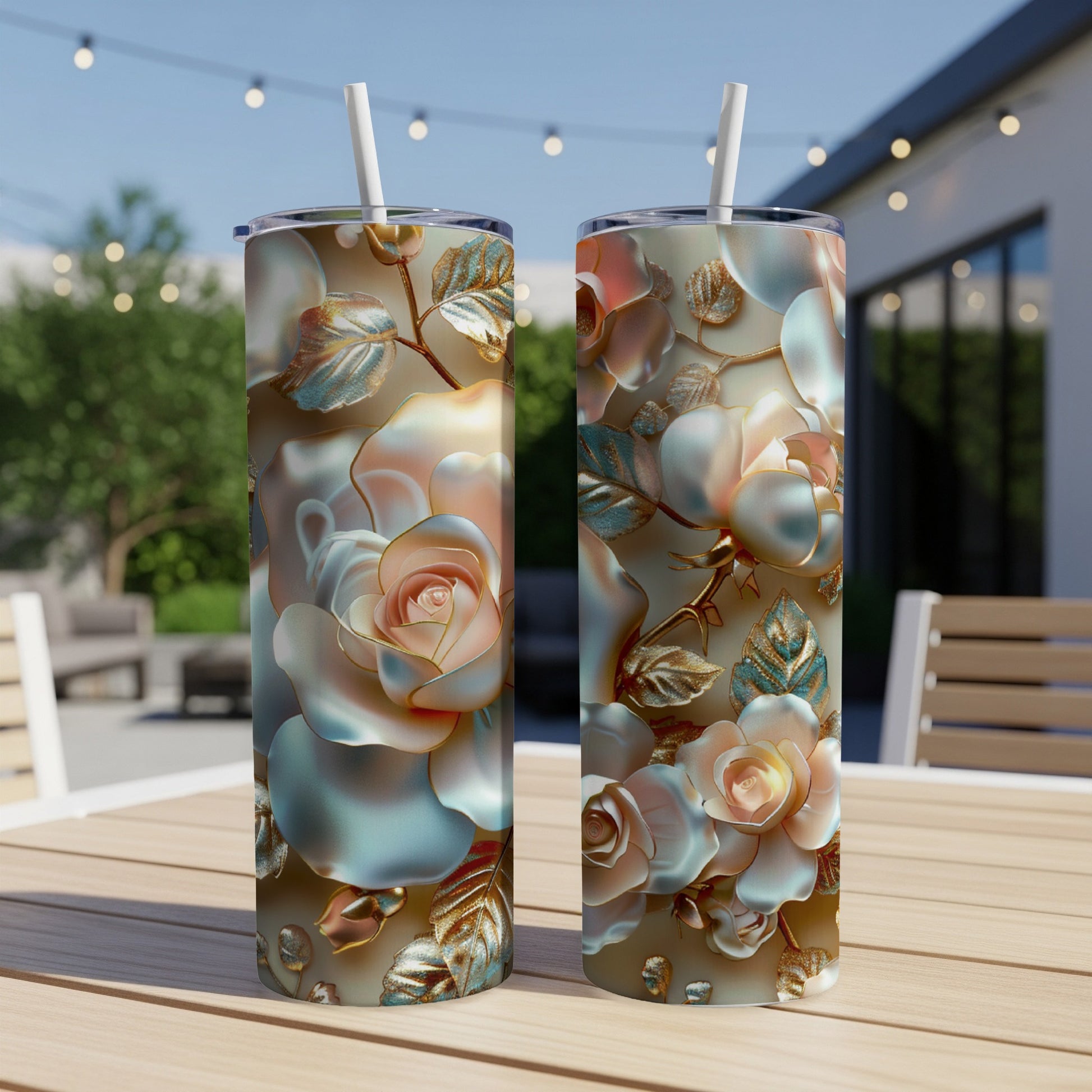 Two tumblers with rose floral design sit on a wooden table outdoors.