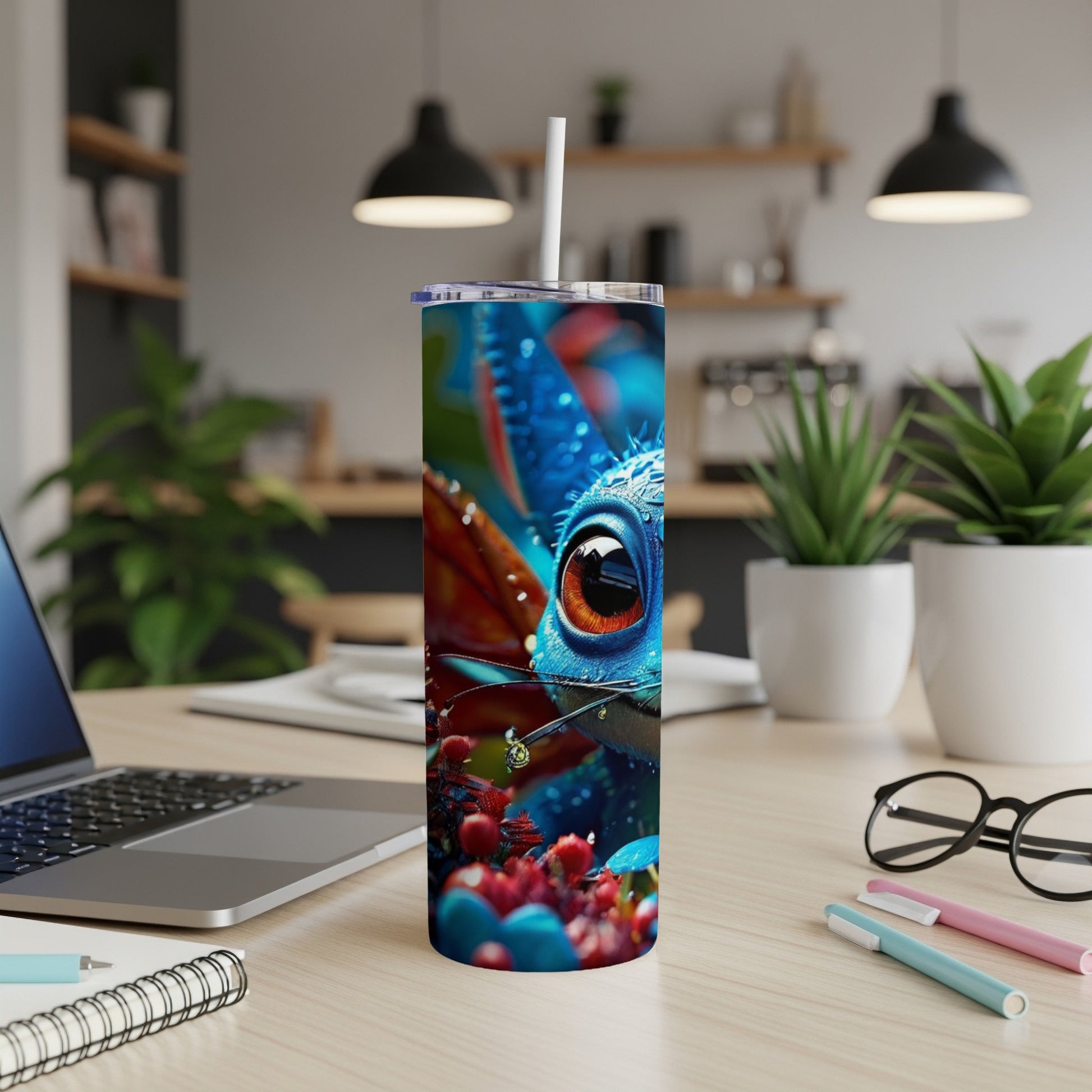 Blue creature with large orange eye on a tumbler with desktop background.