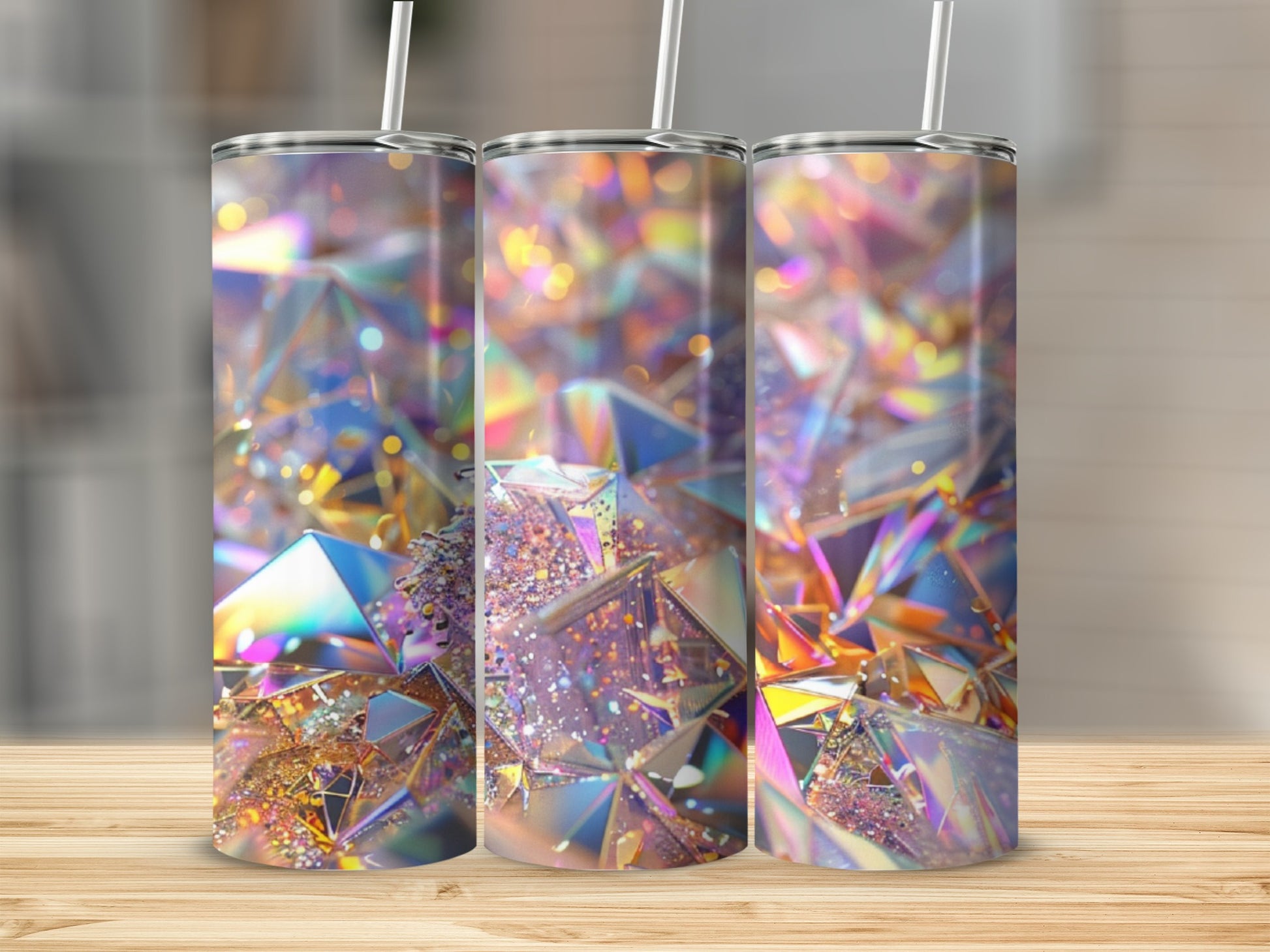 Three tumblers with iridescent, faceted geometric designs on a wooden surface.