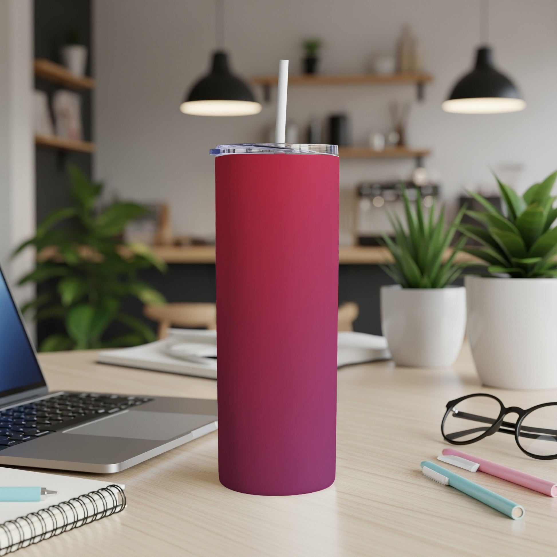 Pink and purple gradient tumbler with straw on a wooden desk.