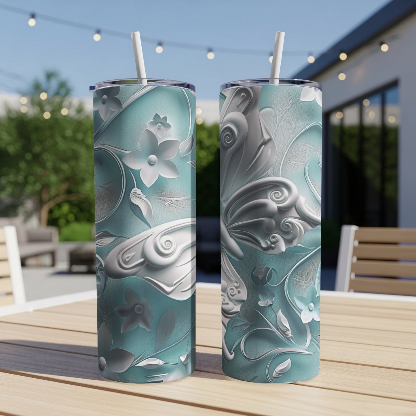 Two teal tumblers with intricate white floral and butterfly embossed designs.