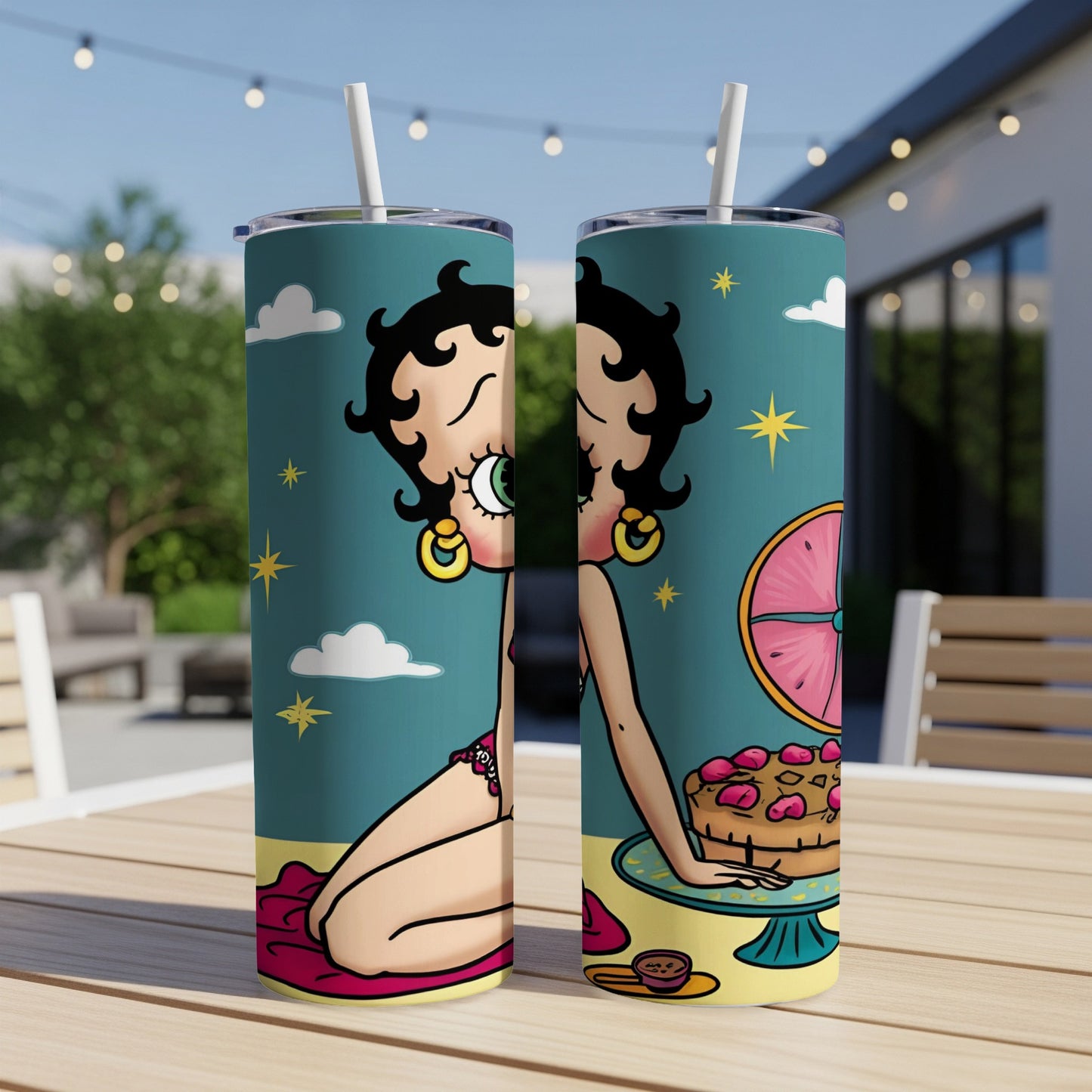 Betty Boop with cake on a table outdoors.