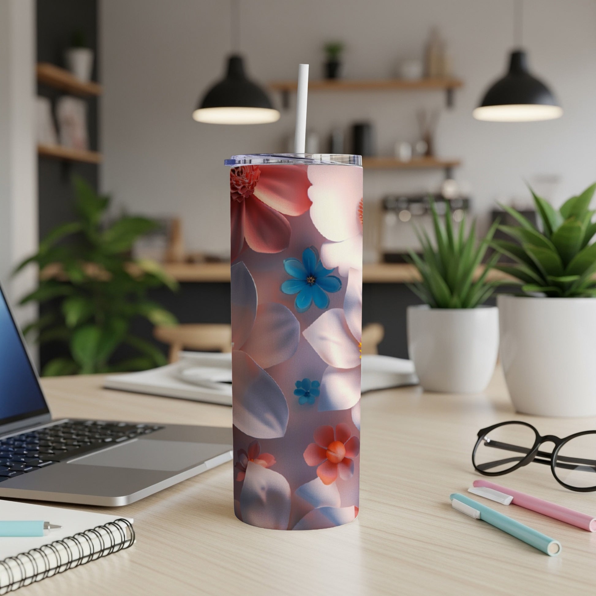 Tumbler with floral pattern and straw on a desk.