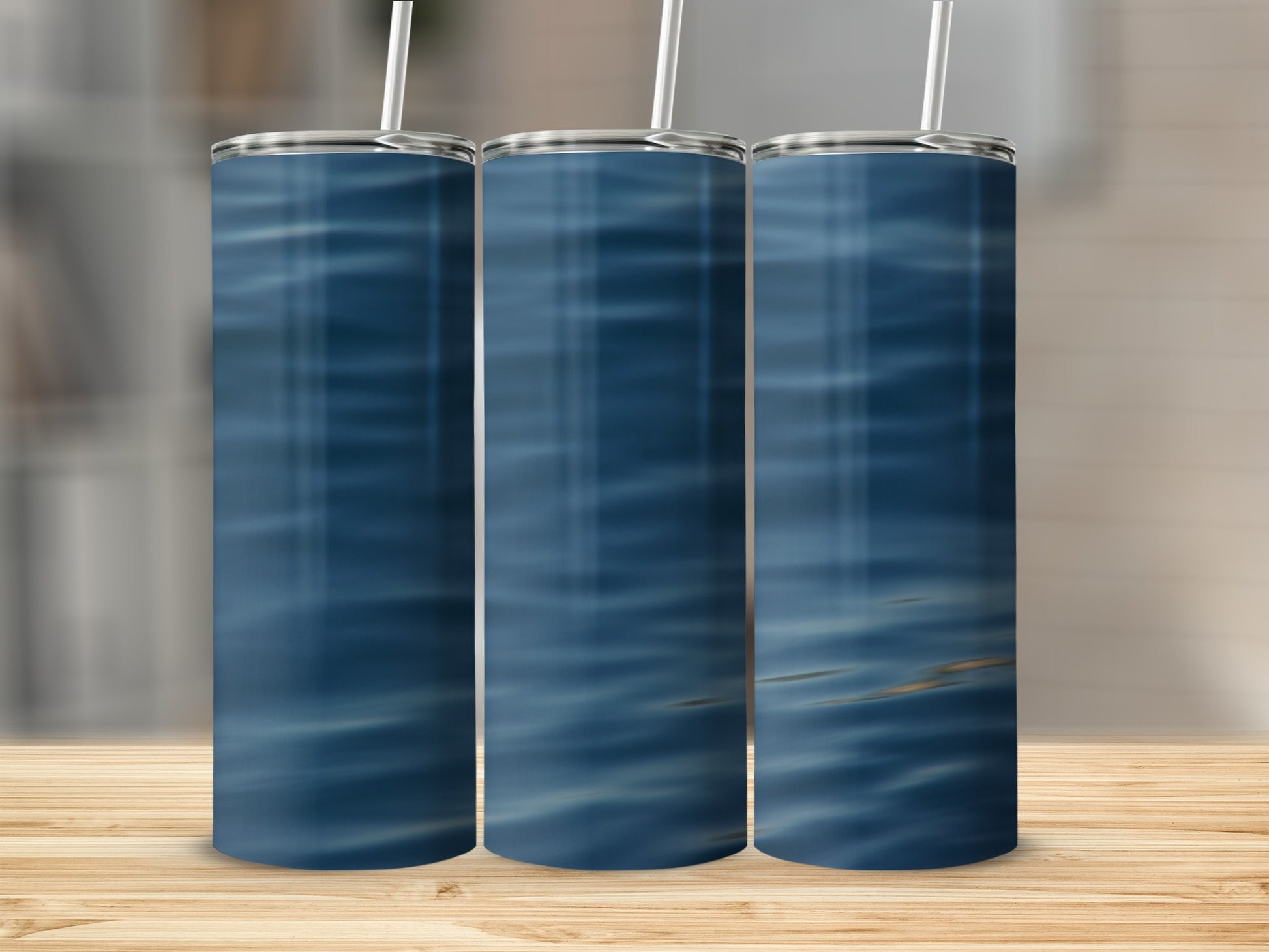 Three tumblers with a blue water ripple pattern stand on a wooden surface.