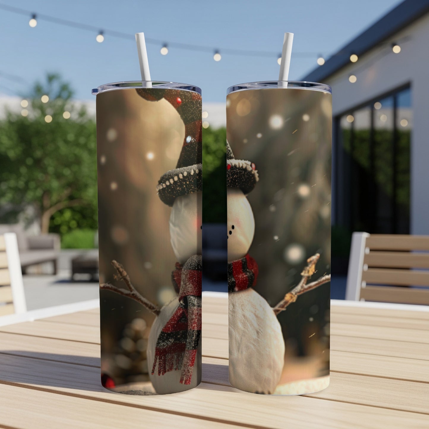 Two snowmen tumblers with Santa hats and scarves on a table outdoors.