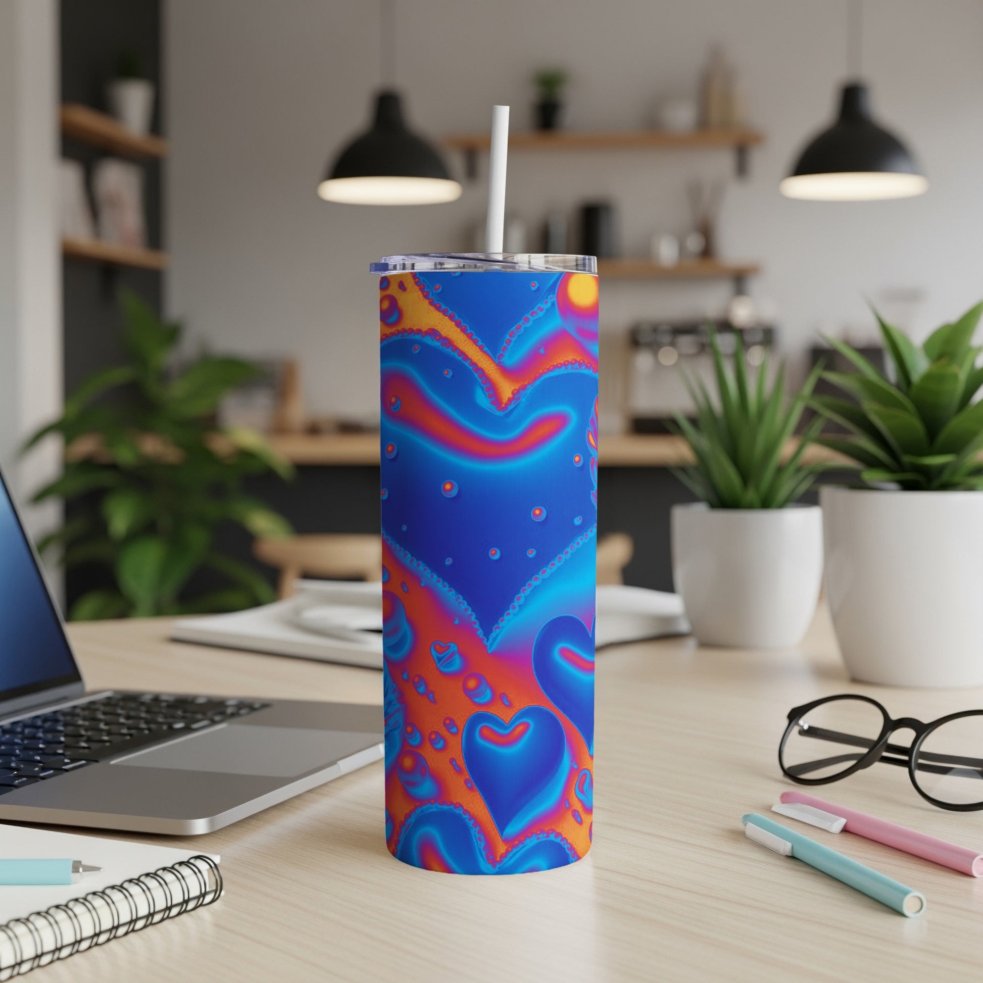Blue tumbler with colorful heart pattern and white straw.