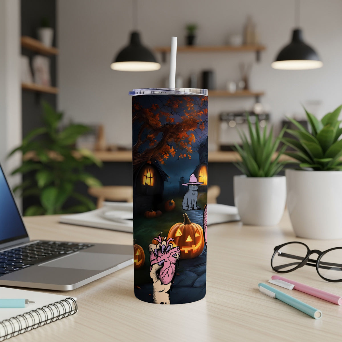 Halloween tumbler with spooky graveyard scene, a cat in a witch hat, and a hand holding a heart.
