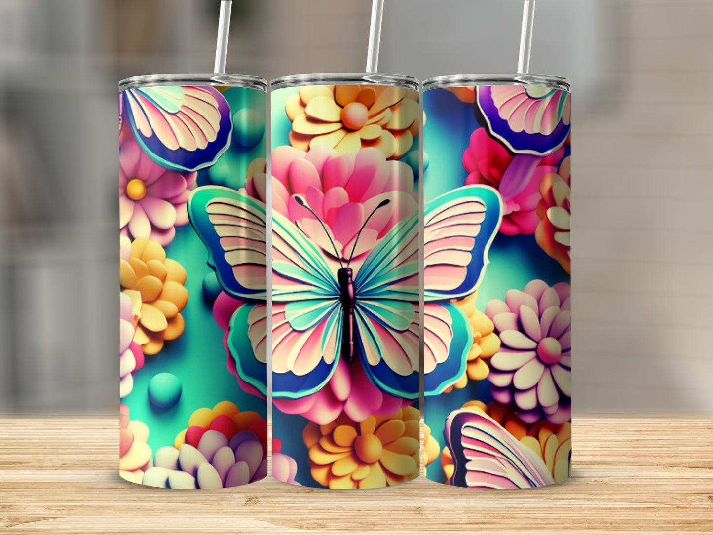 Three tumblers with colorful butterfly and floral designs on a wooden surface.