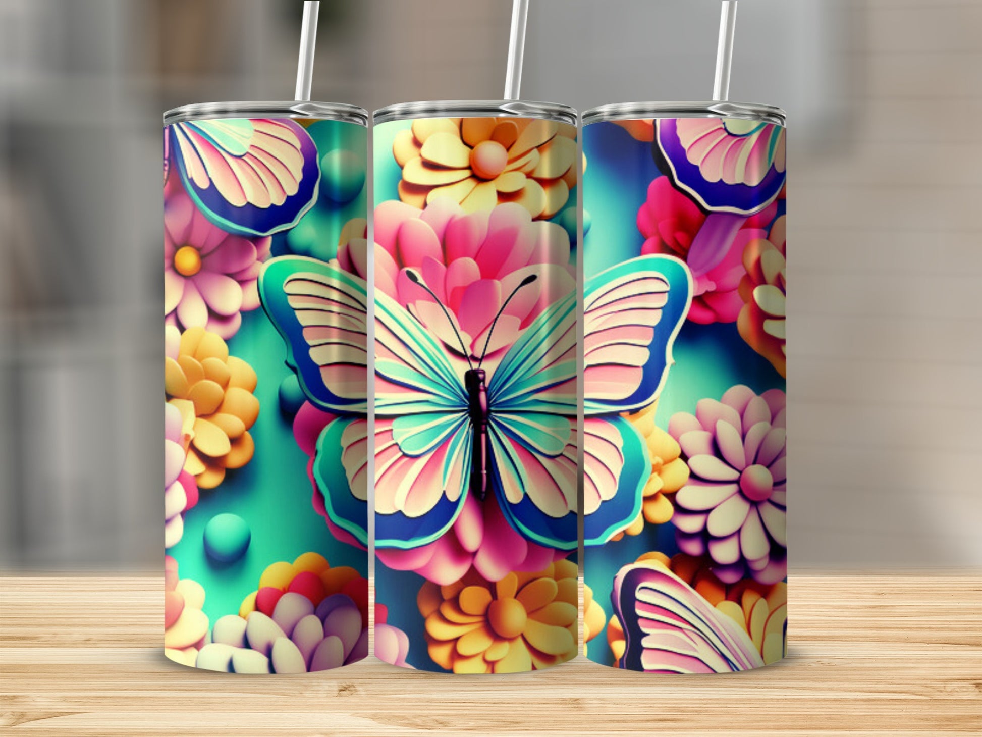 Three tumblers with colorful butterfly and floral designs on a wooden surface.