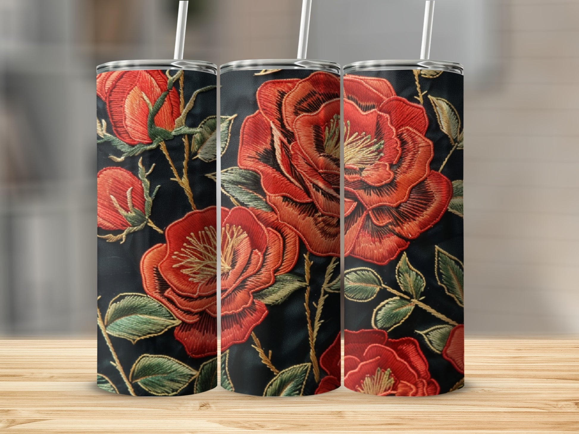 Three tumblers with embroidered red roses on a black background.
